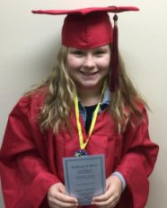 A young girl in a red graduation cap and gown holding a diploma, smiling. She is a Vision Therapy graduate from Superior Eye Health.