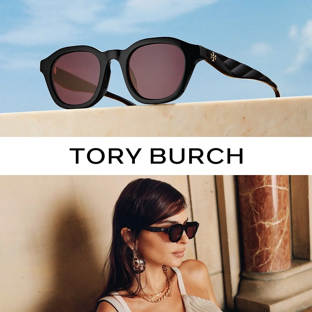 A pair of black Tory Burch sunglasses with pink-tinted lenses resting on a beige marble surface against a blue sky background, and a woman wearing similar sunglasses, earrings, and necklaces leaning against a beige wall with a marble column.