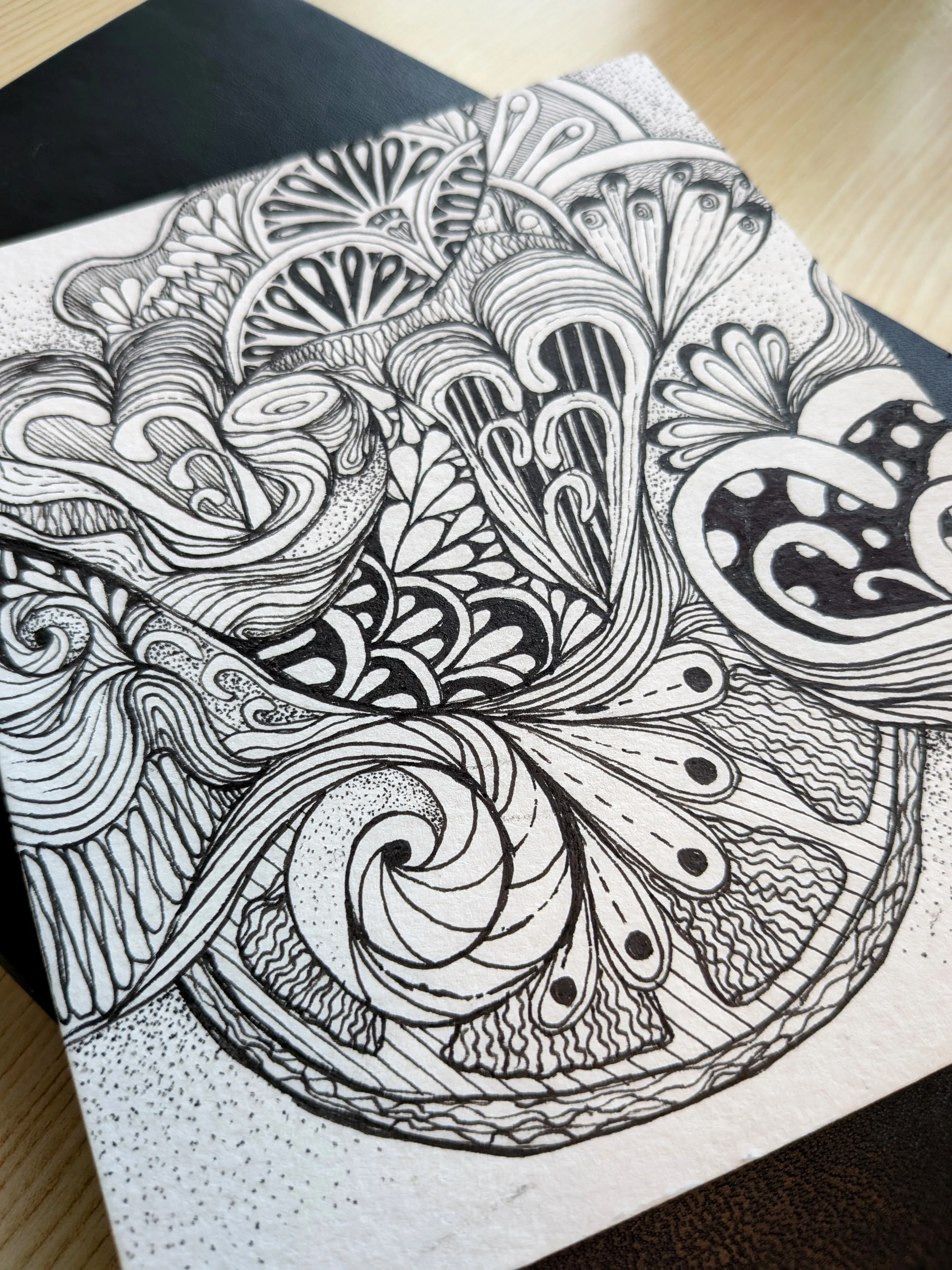 Black and white abstract drawing with intricate patterns and swirling designs.