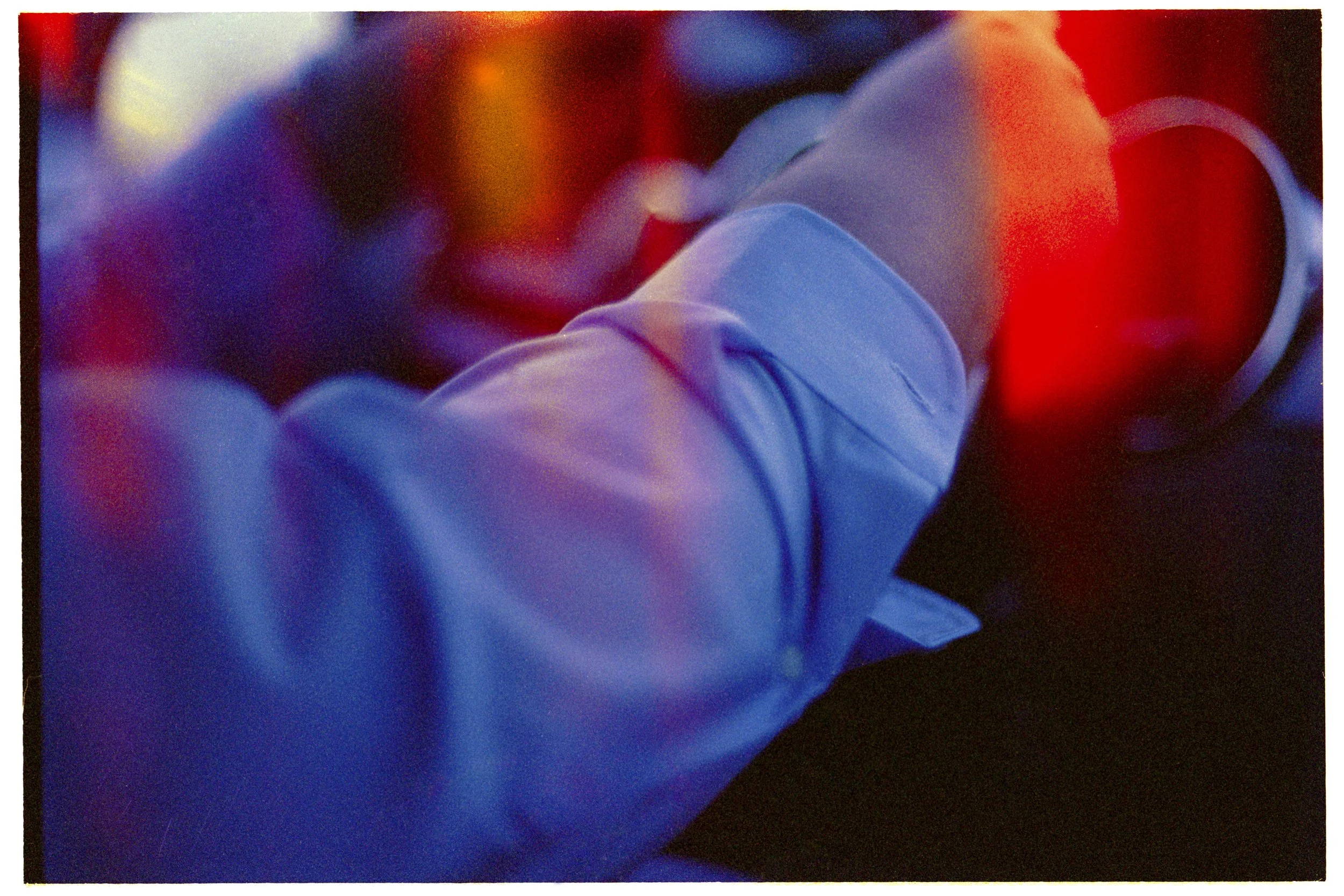 Close-up of a gloved hand reaching towards a glowing red button or switch.