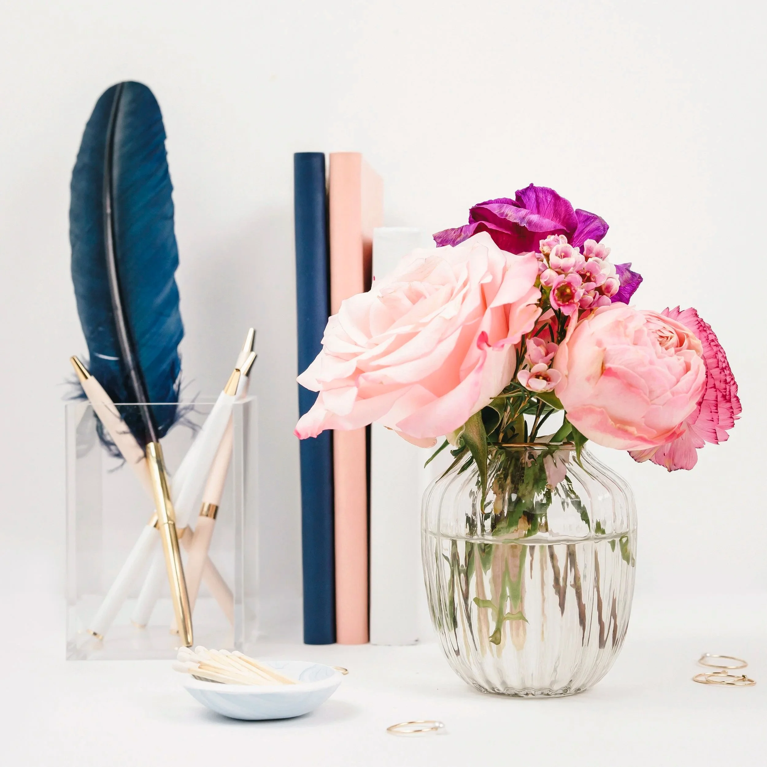 Home decor with flowers and books representing real mom life, beauty favorites, and everyday home inspiration