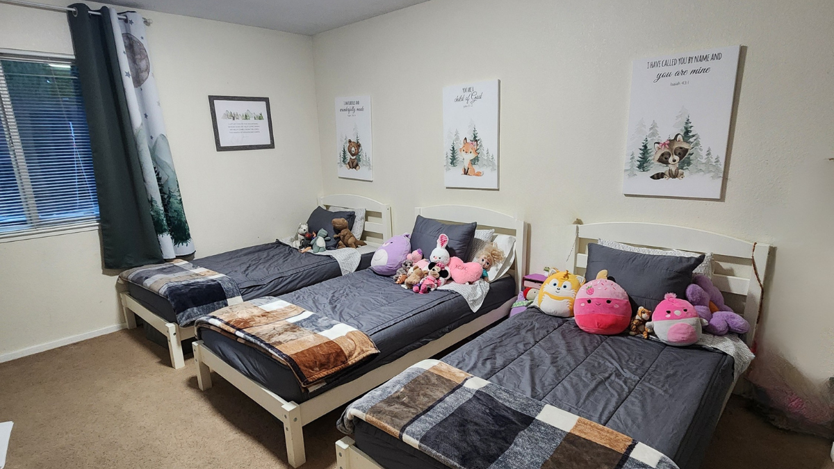 Kids shared bedroom ideas with three beds in one room, gender neutral woodland decor, budget-friendly setup for siblings