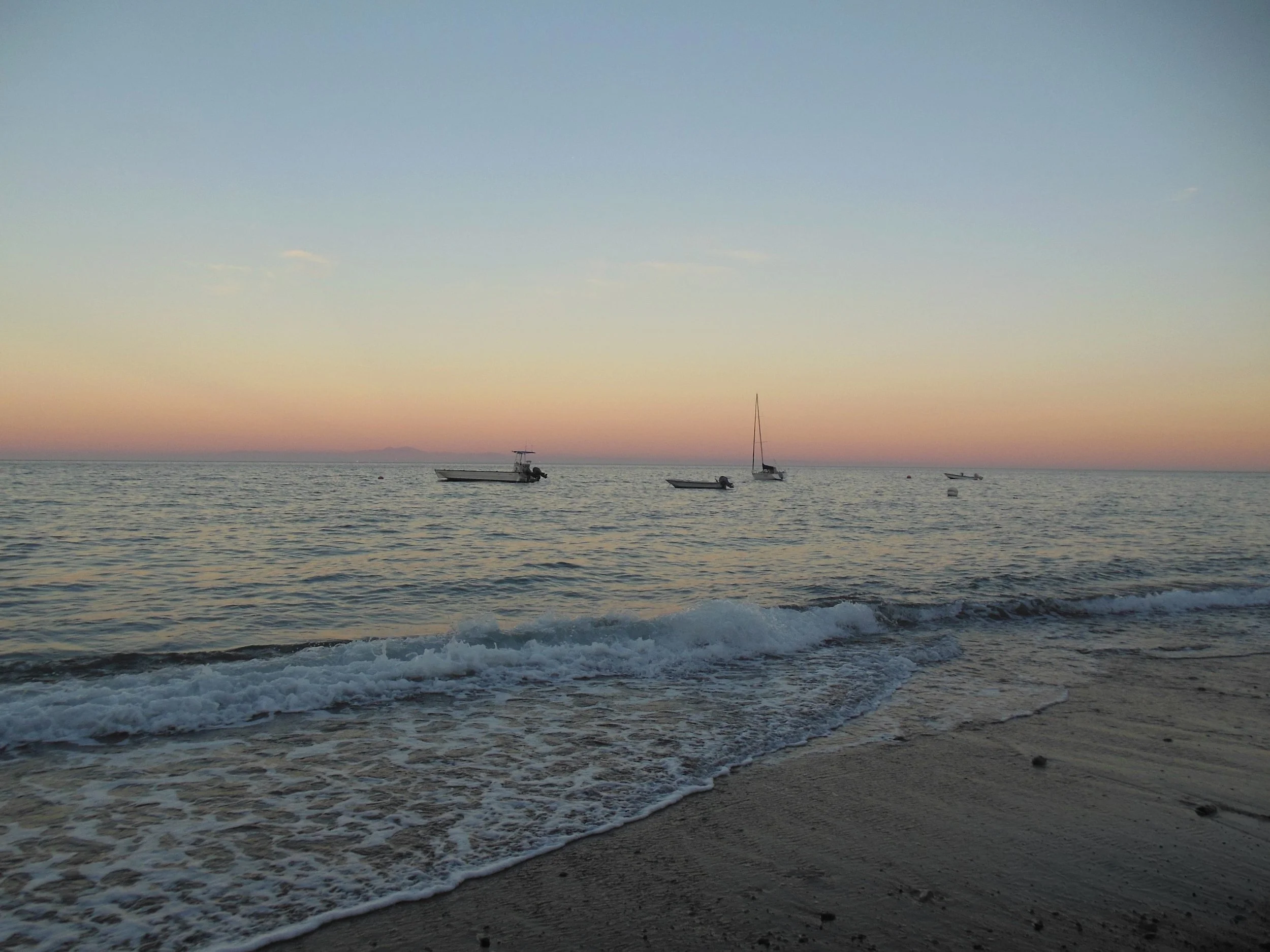 Last light off the shore, fishing boats anchor for the night. Nikon s600