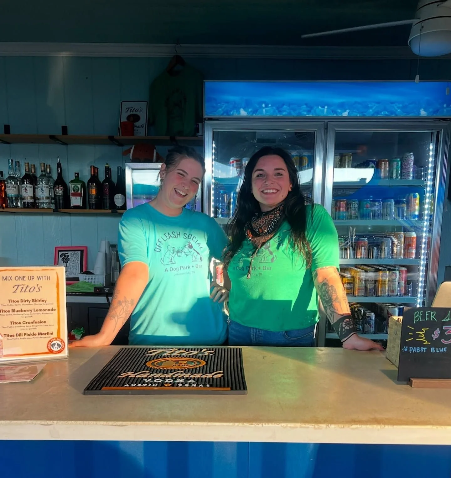 Bartender serving drinks at Off Leash Social's outdoor bar in Johnson City