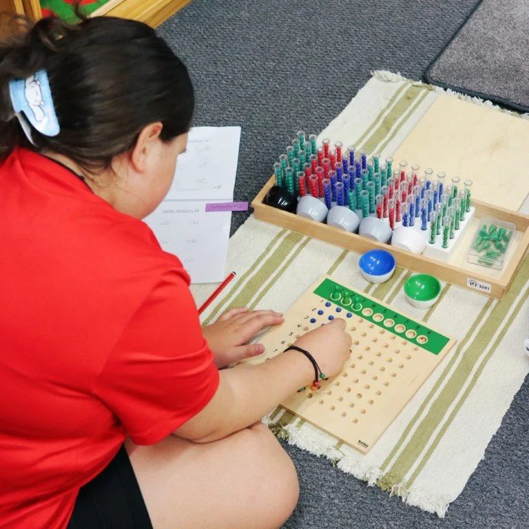 An Upper Primary student completing a Math Montessori Job