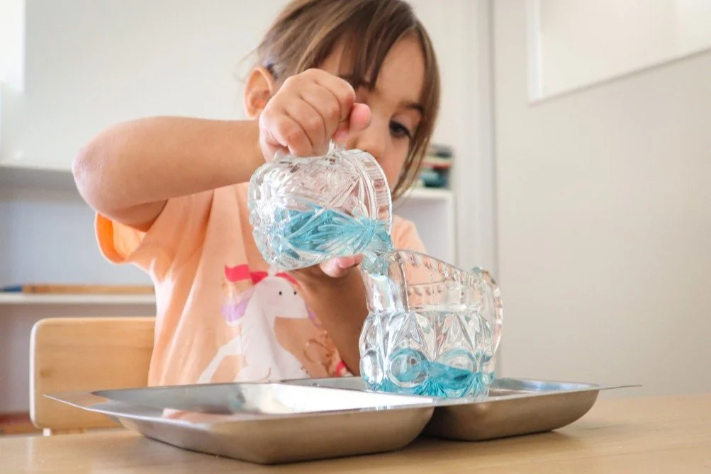 a Kindy student at daycare completing a pouring Montessori job