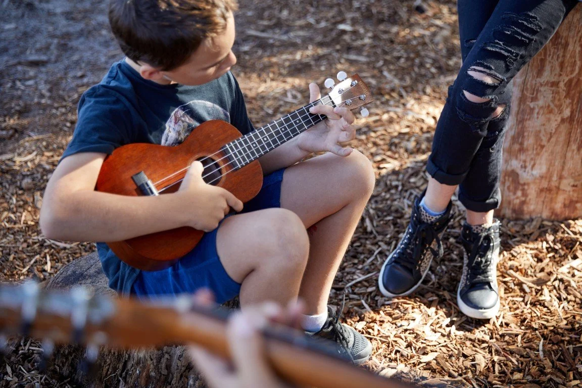 A student playing guitar in music lessons