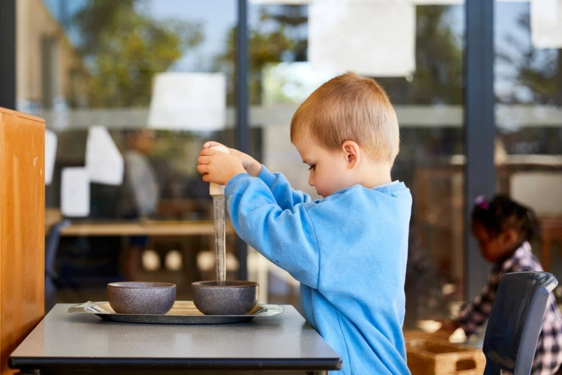 A childcare student concentrating on a Montessori job
