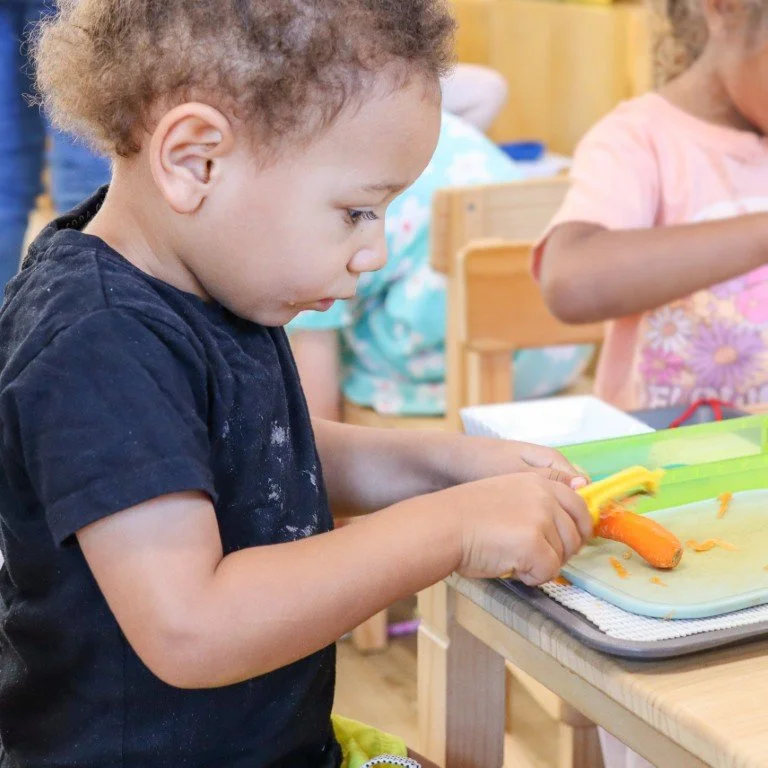 A young child prepares his own food at our Port Kennedy childcare centre