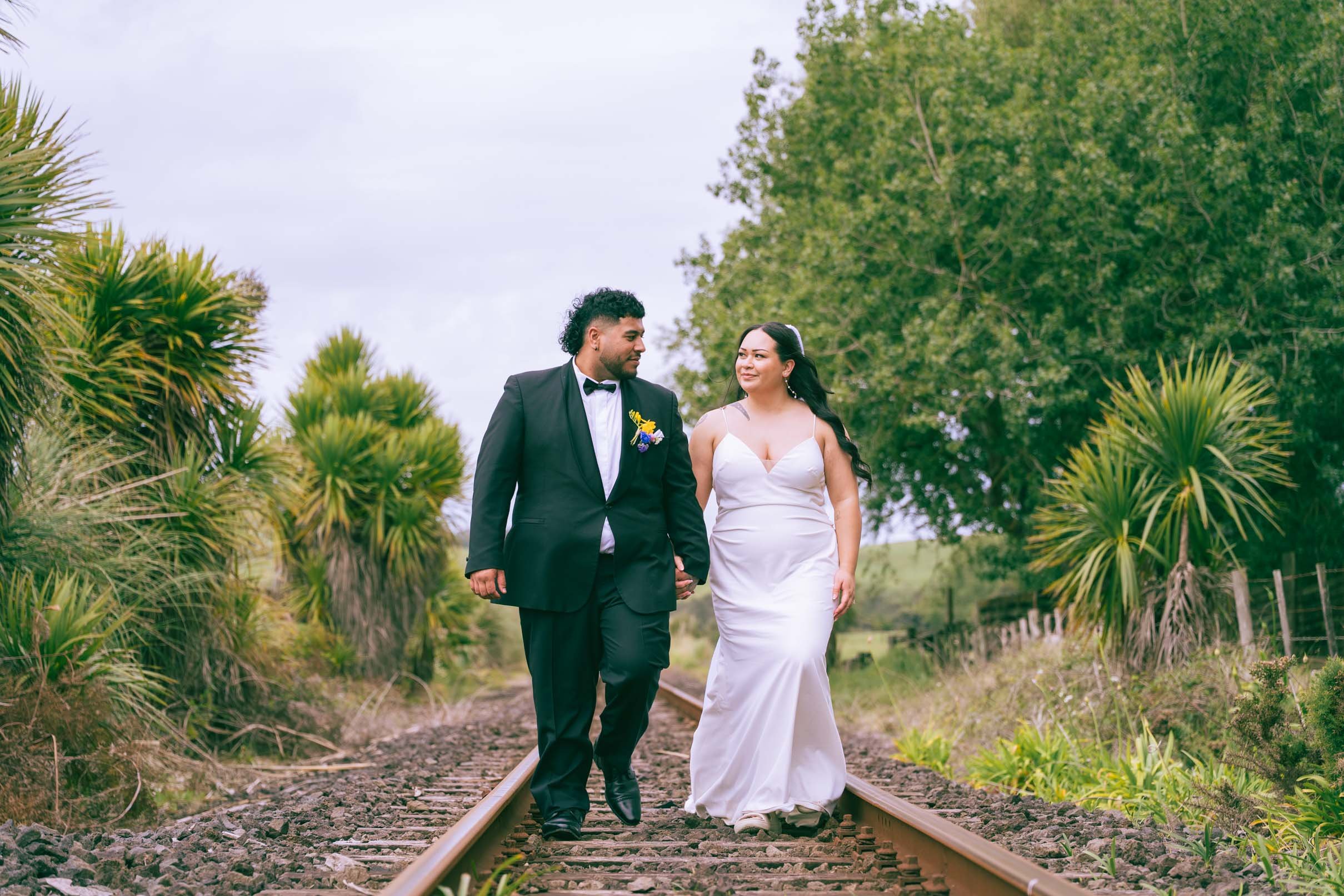 Married couple walking down train track - candid and comfortable couples photo