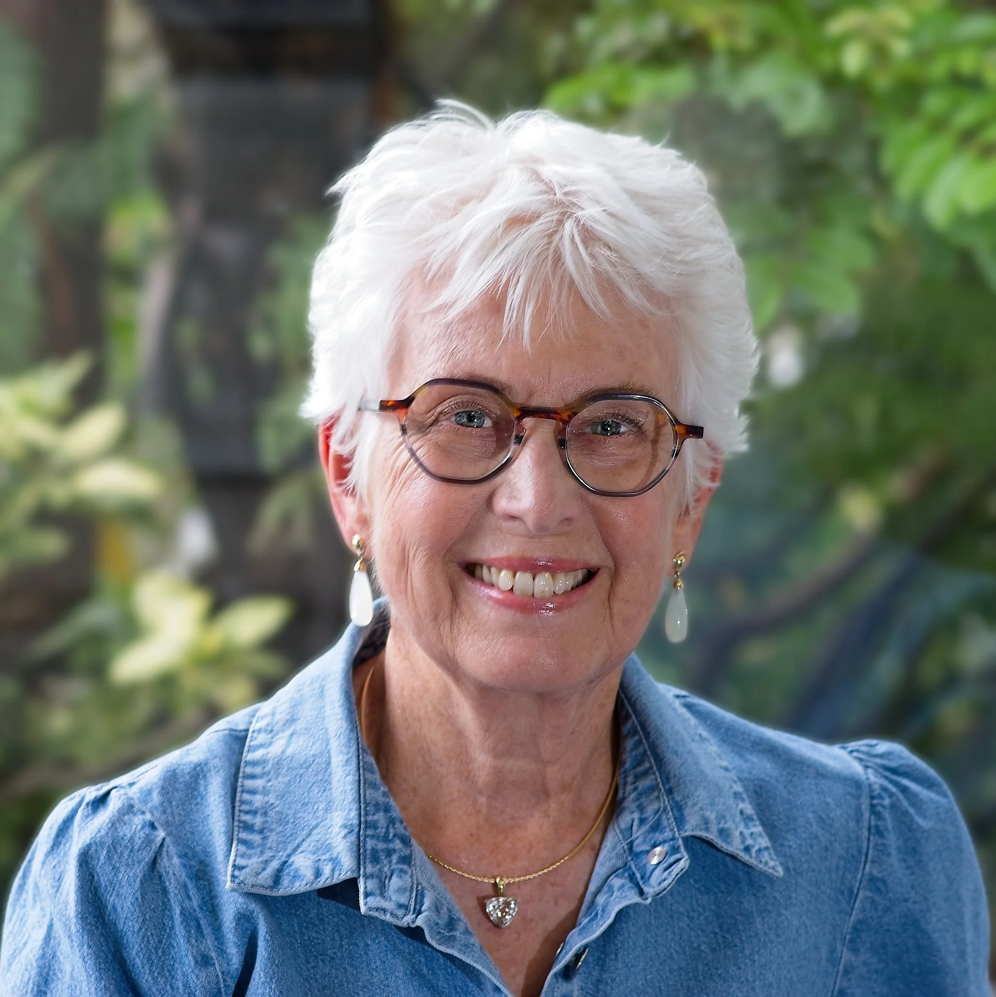 Helen and earrings smiling in a natural outdoor setting.