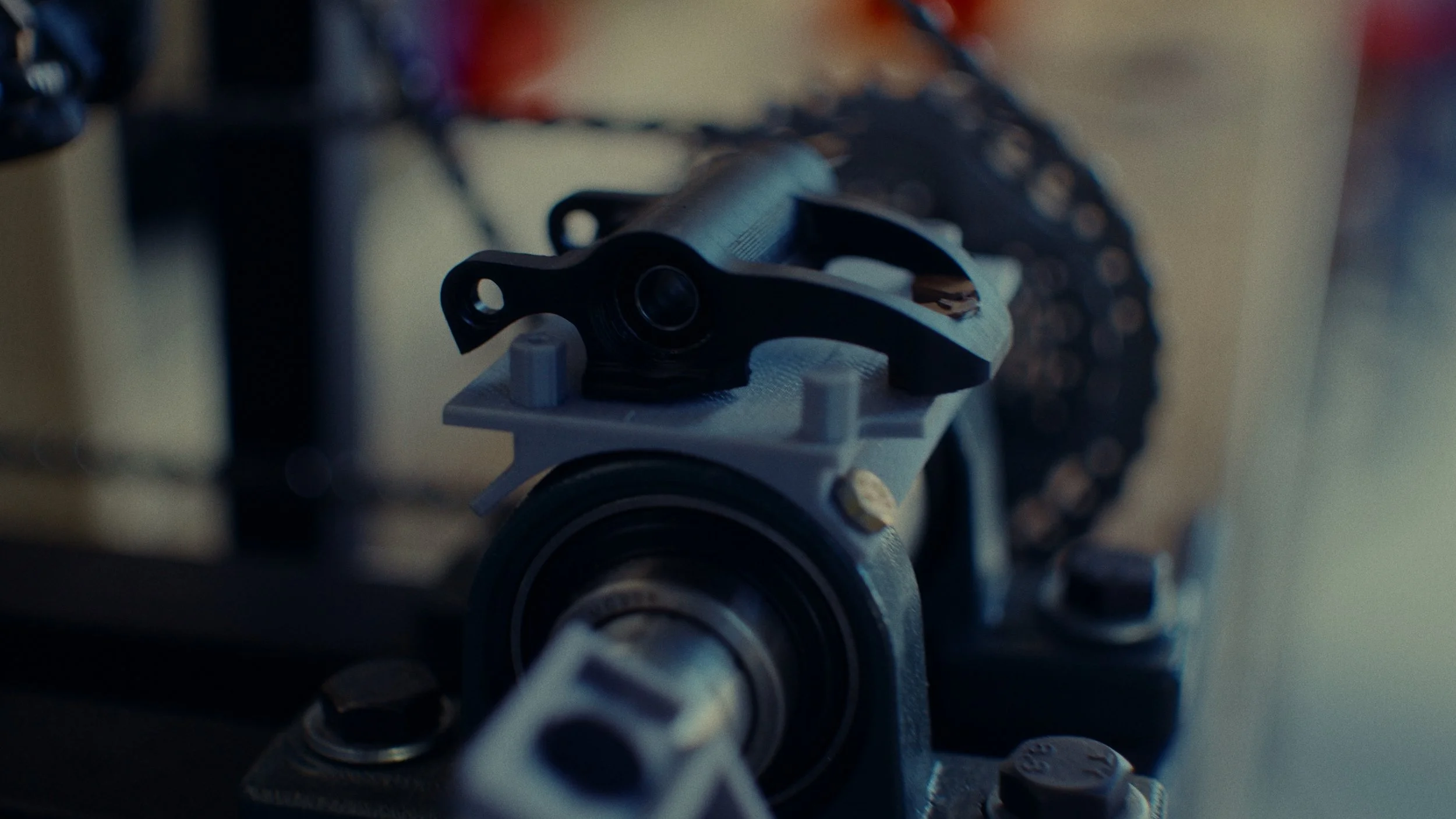 Vue rapprochée d'une pièce de vélo, avec un dérailleur et une chaîne, dans un atelier.