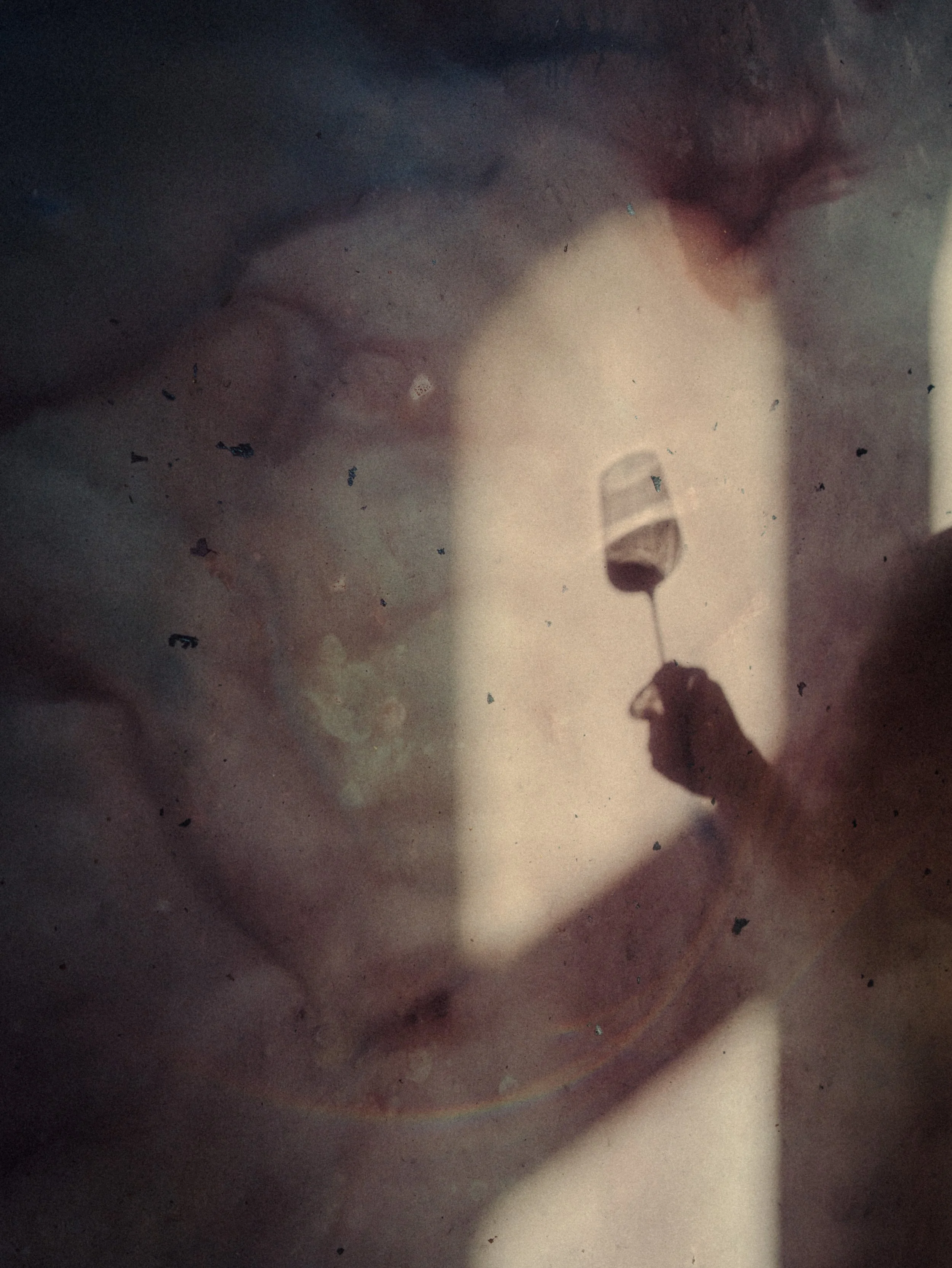 Un bonbon ou une sucette colorée, tenu par une main en silhouette, avec un fond flou et sombre.