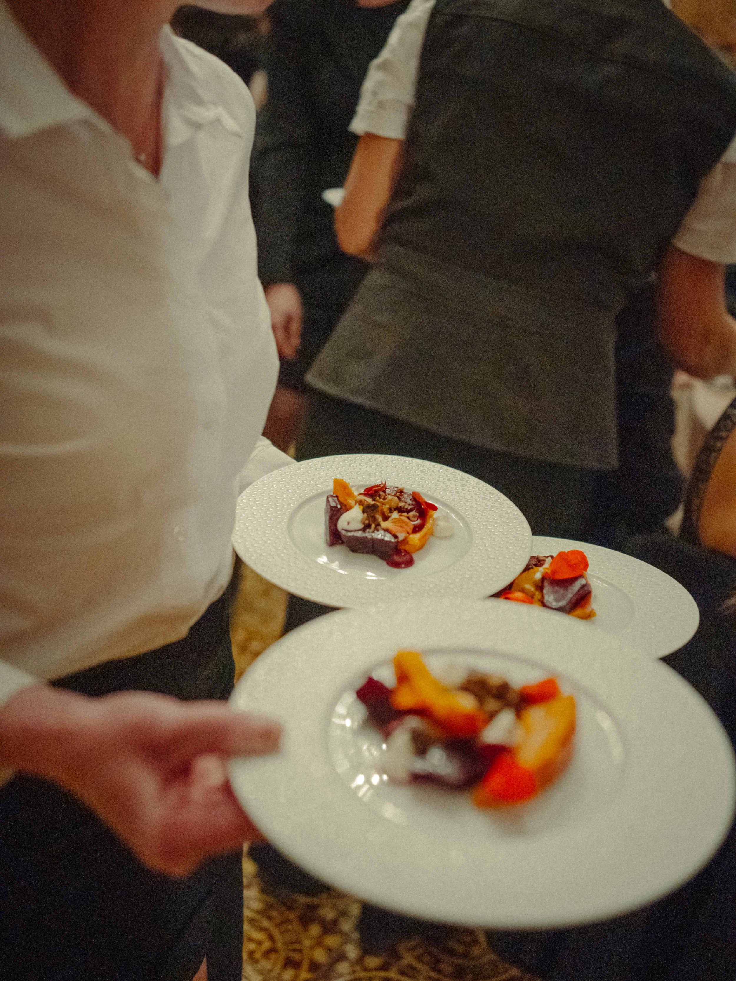 Serveur présente des assiettes de desserts colorés dans un restaurant