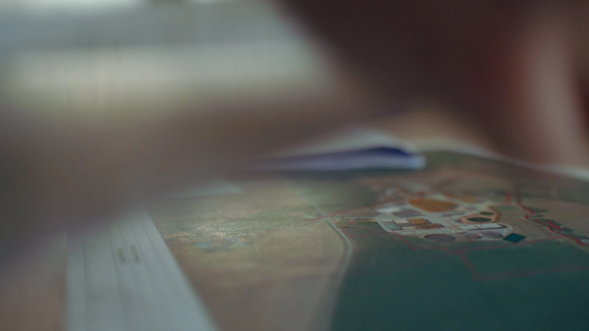 Une vue floue d'une carte ou d'un plan posé sur une surface, prise sous un angle bas et avec un flou artistique.