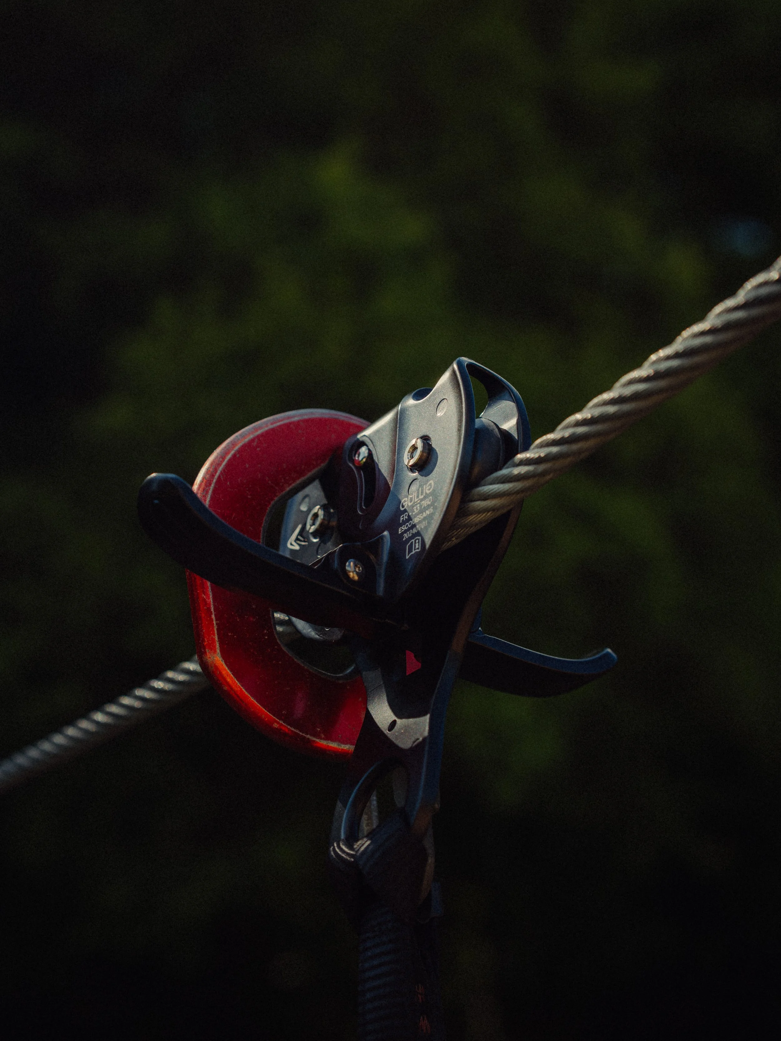 Mousqueton de sécurité fixé à une corde d'escalade dans un environnement naturel.