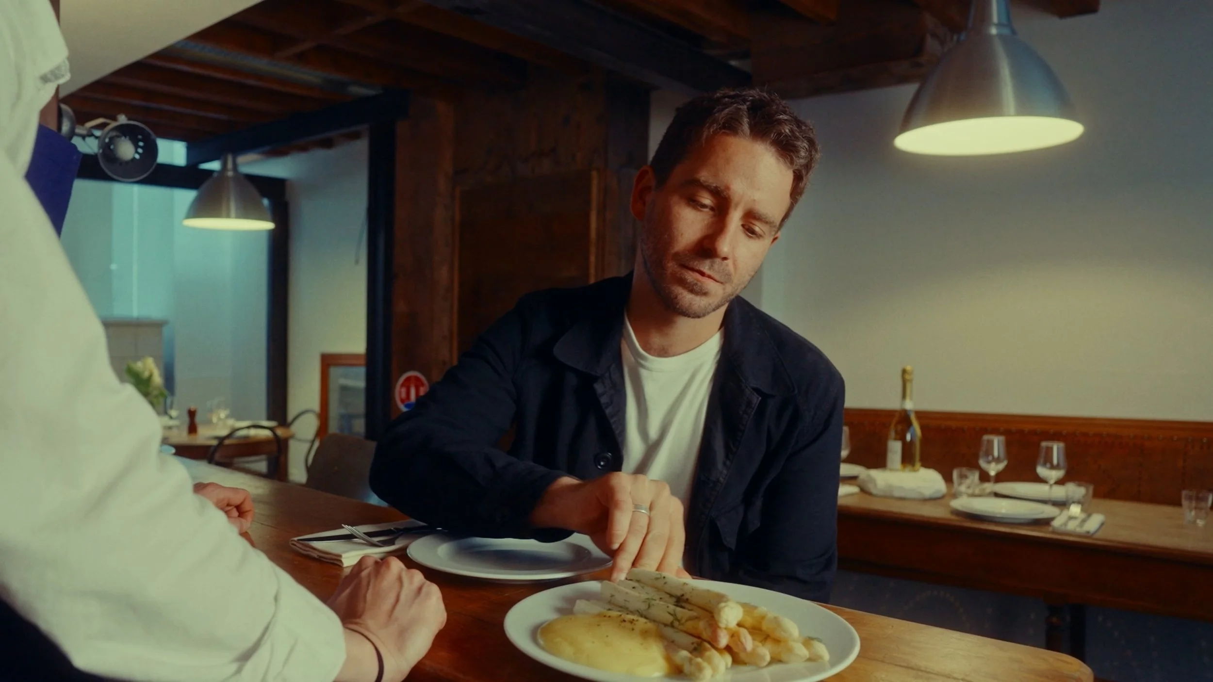 Un homme regarde un plat de légumes et de poisson dans un restaurant