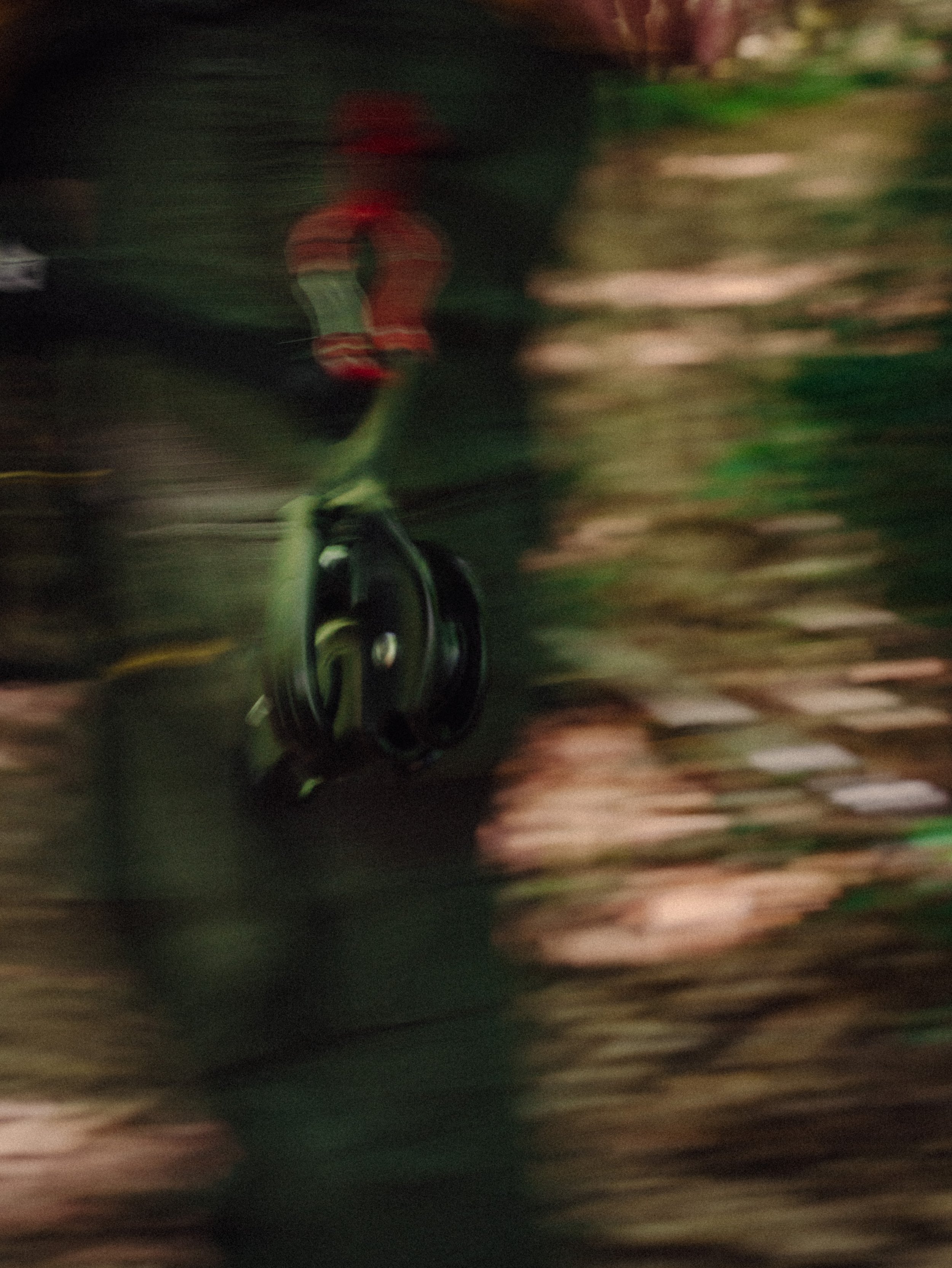 Vélo en mouvement avec un réflecteur rouge, flou due à la vitesse, dans un environnement naturel ou urbain.