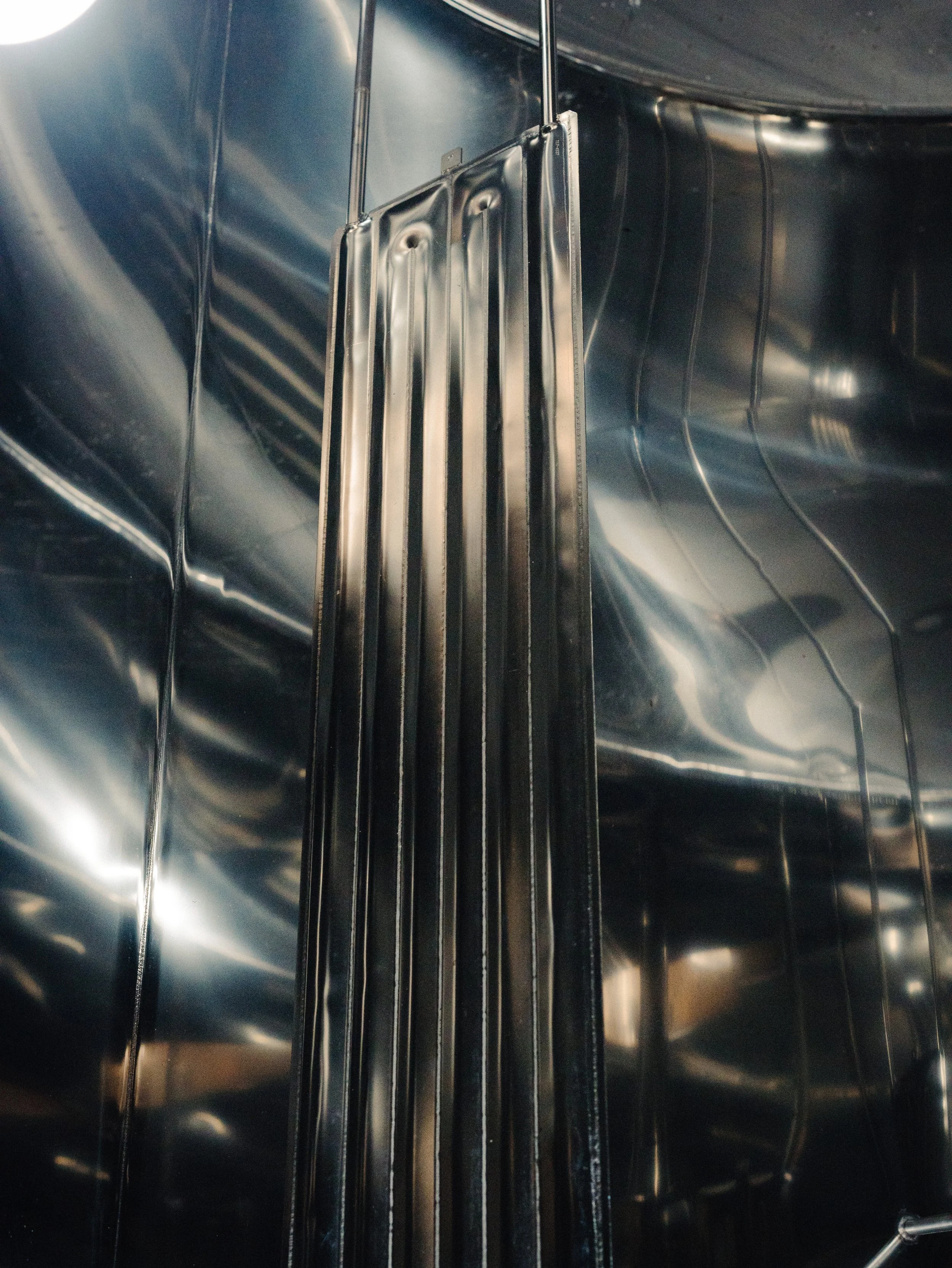 Une pièce en acier inoxydable avec une rampe d'échelle suspendue verticalement au mur.