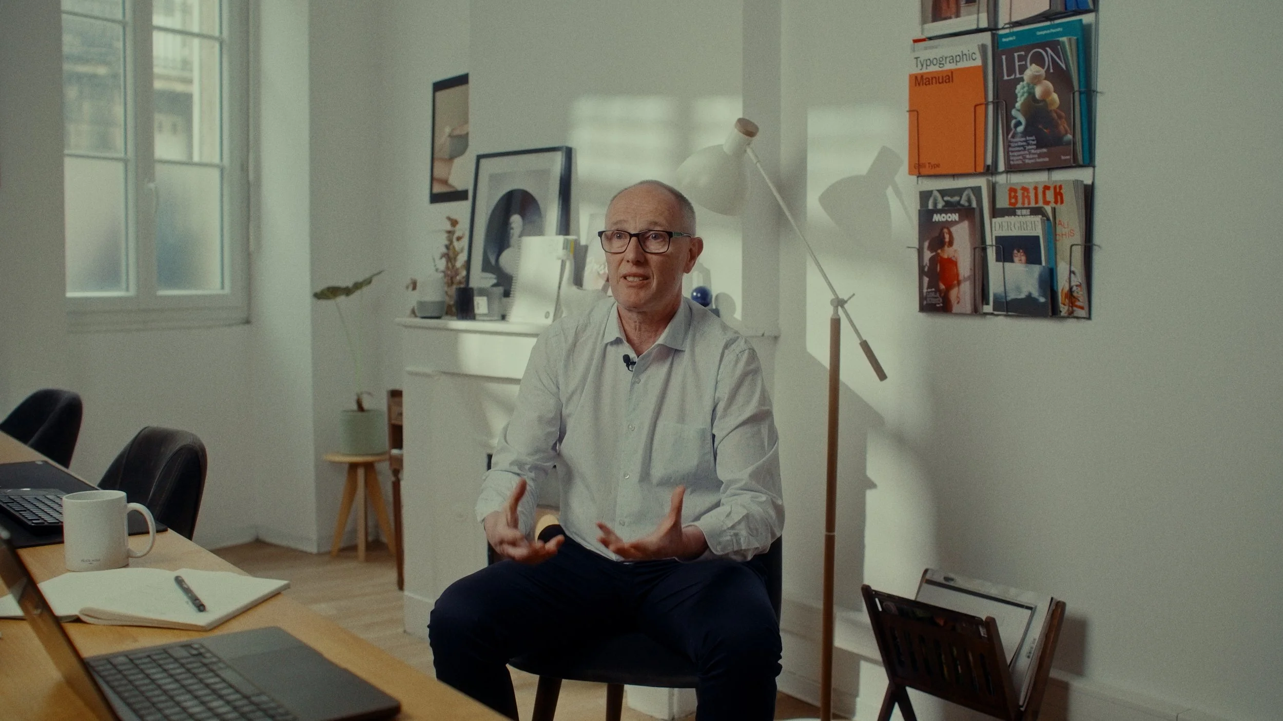 Un homme assis dans un bureau, parlant lors d'une interview ou d'une conversation.