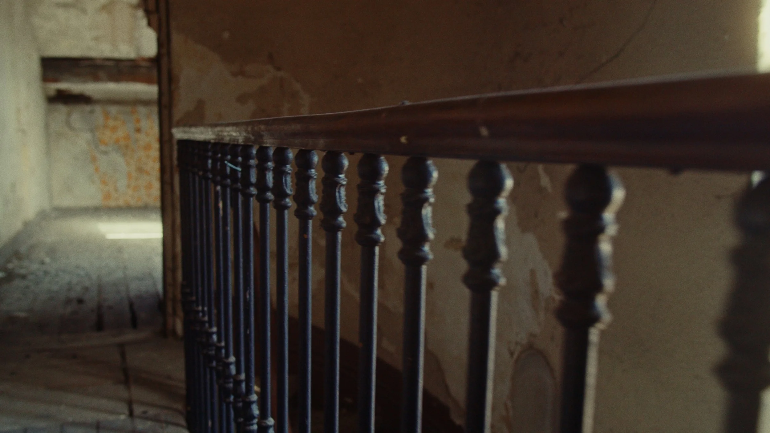 Barrière en métal dans un bâtiment ancien avec murs dégradés.