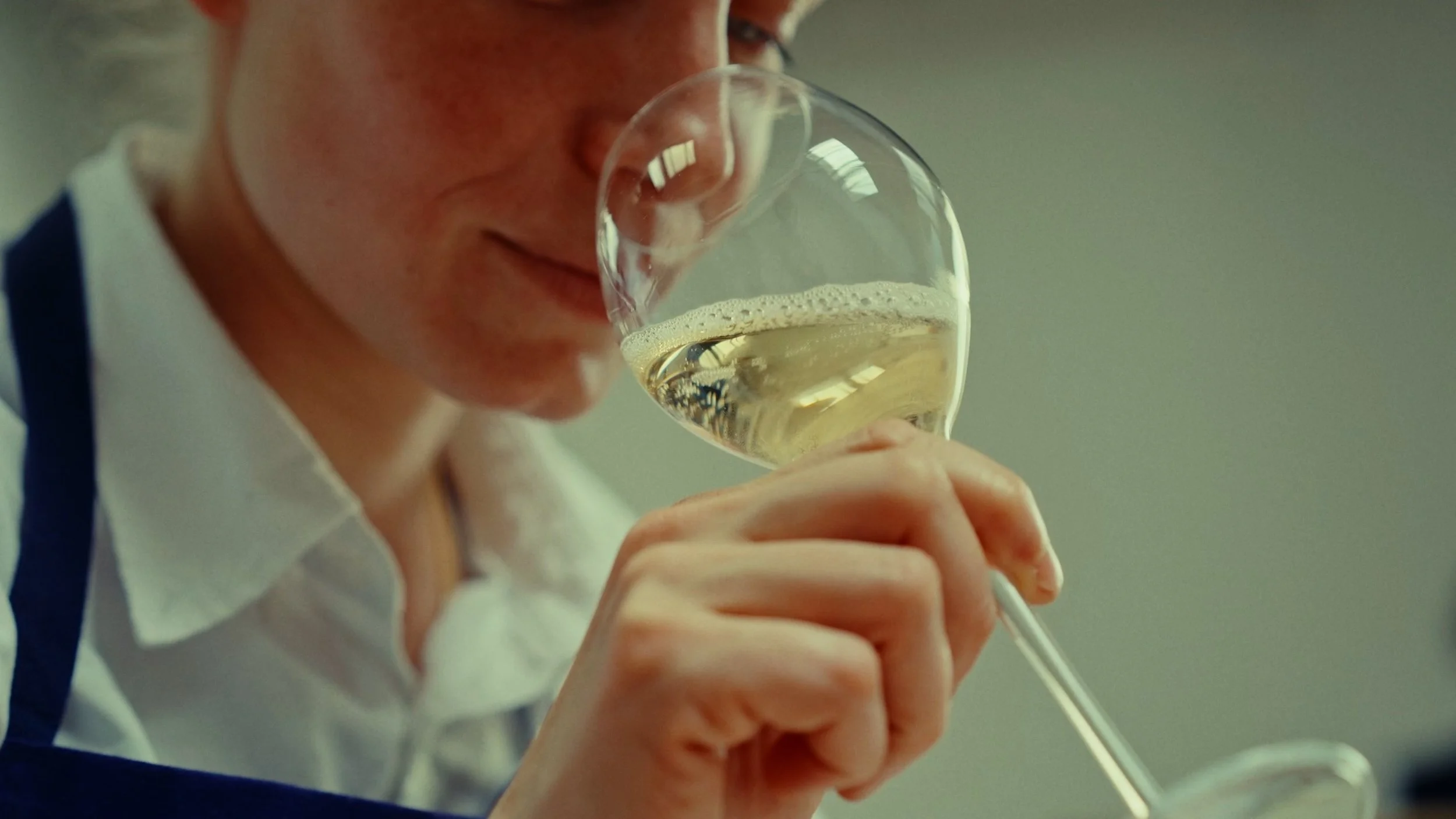 Femme dégustant un verre de vin blanc dans un environnement intérieur