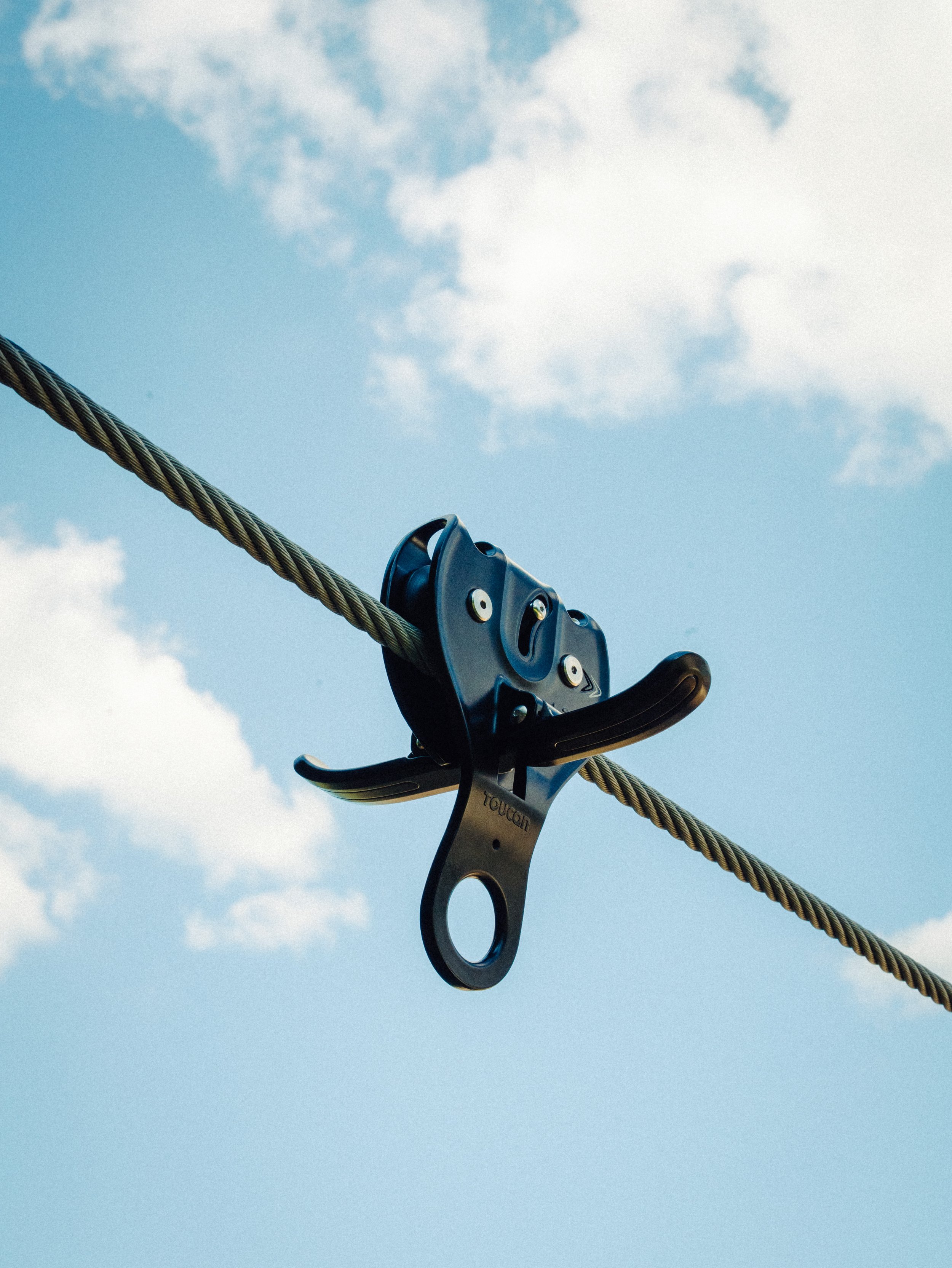 Un harnais de sécurité fixé à une corde suspendue dans le ciel avec des nuages