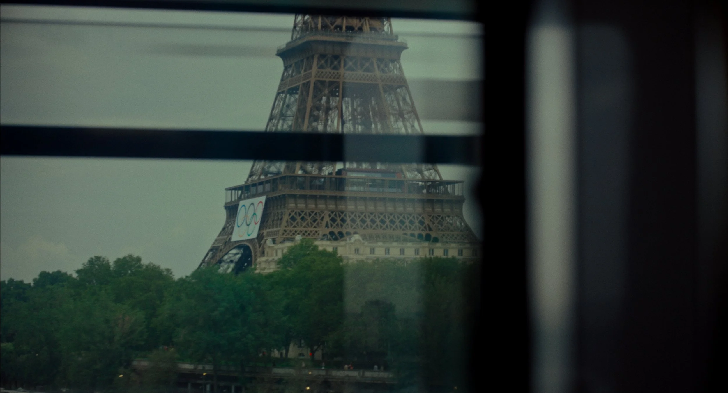 Vue de la tour Eiffel à travers une fenêtre avec des reflets