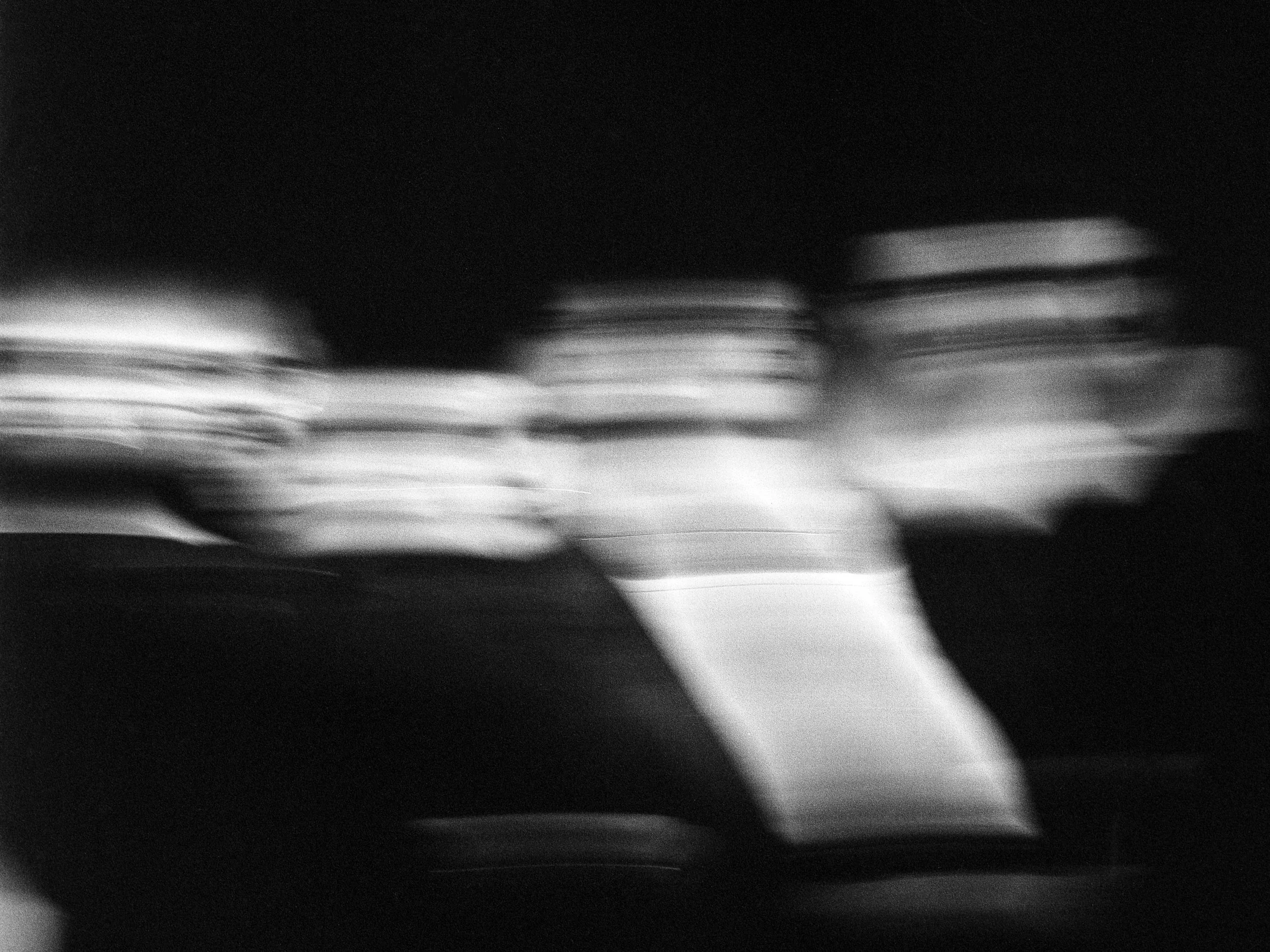 Photo floue de trois personnes en mouvement, probablement dans une pièce sombre.