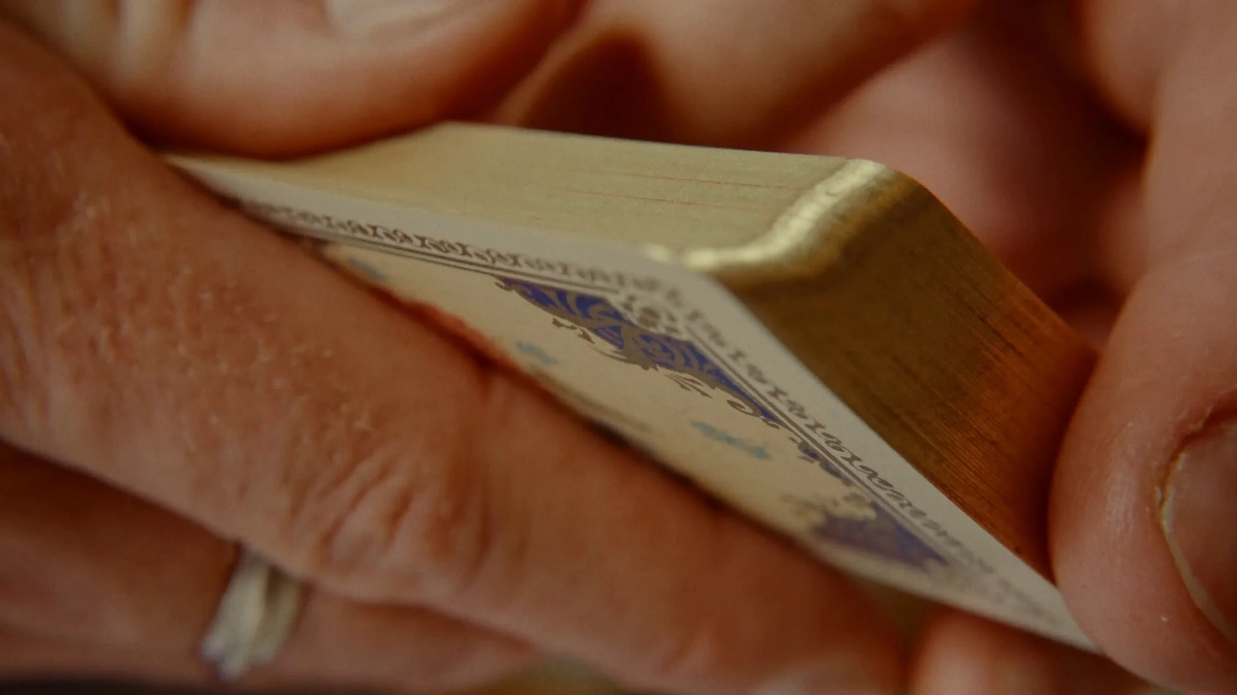 Mains tenant une boîte d'allumettes avec la face inférieure visible, montrant le texte imprimé.