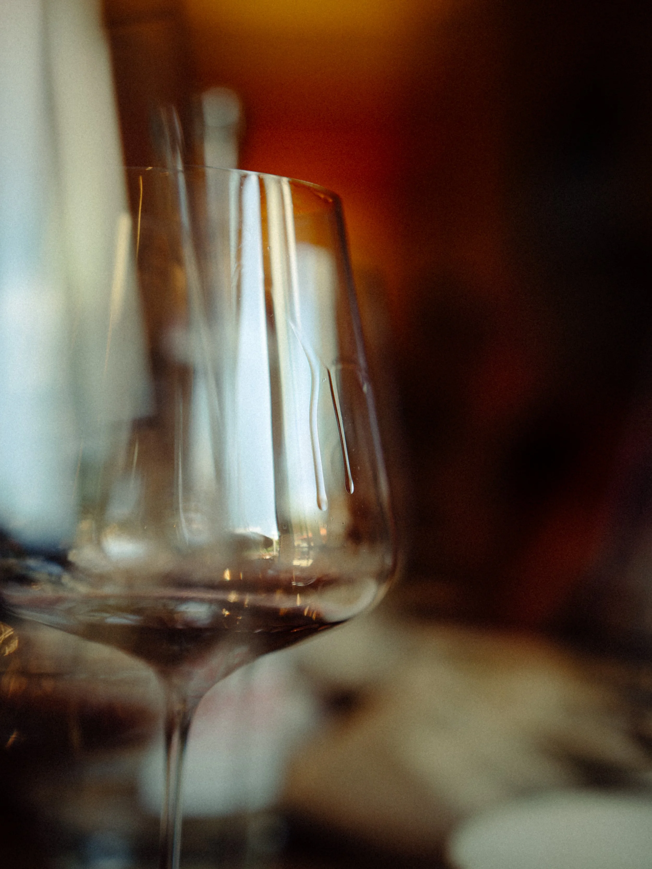 Verre à vin rouge à moitié rempli, vue rapprochée, flou artistique, ambiance chaleureuse