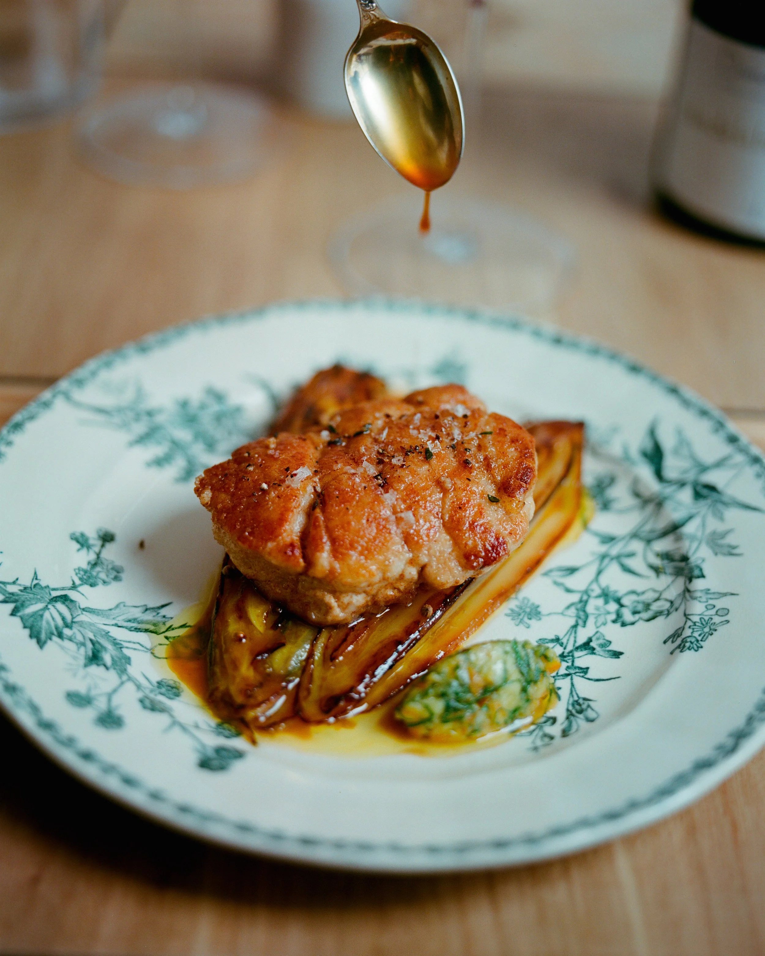Un plat de poulet croustillant avec une sauce, présenté avec une aubergine grillée et une purée végétale.