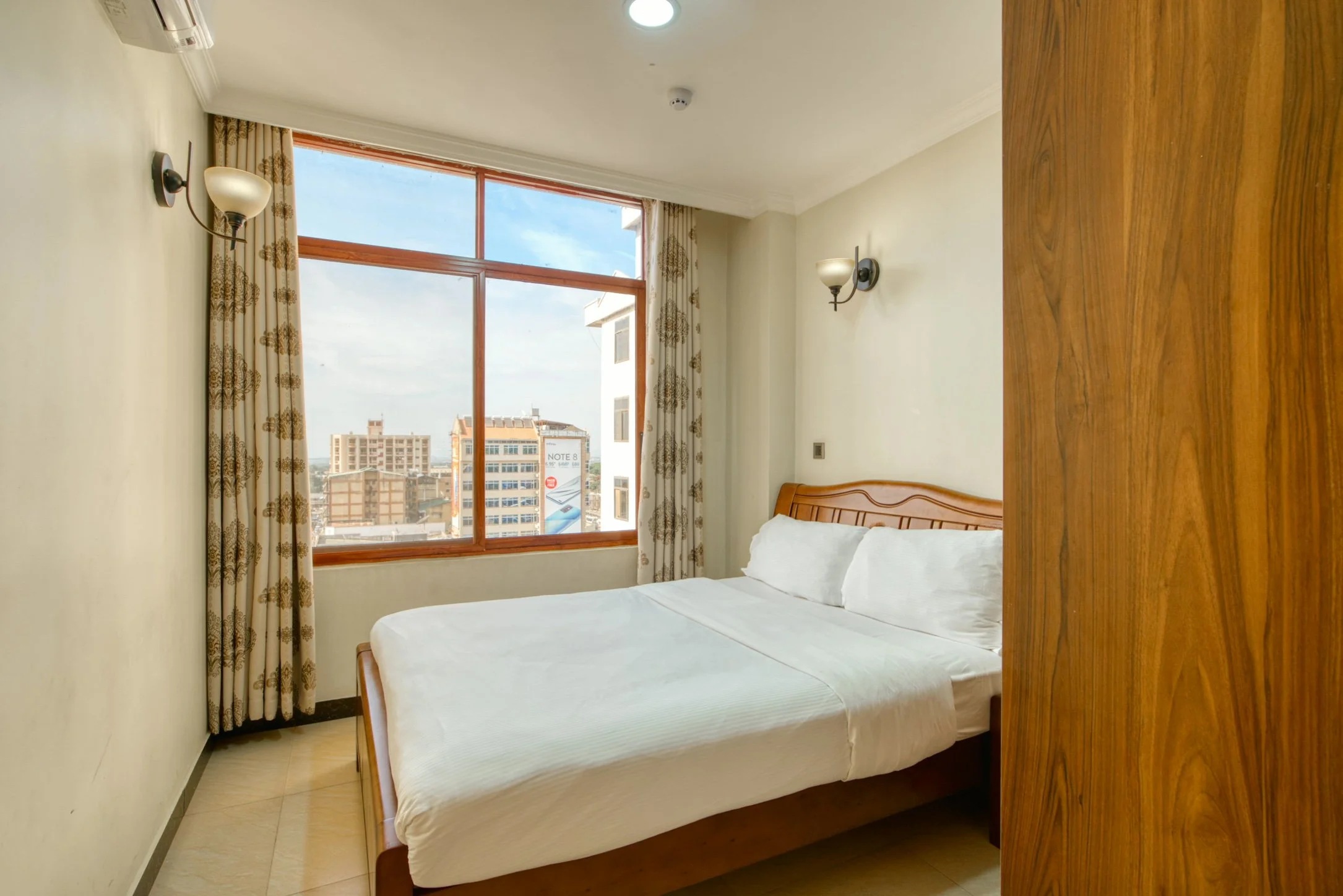 Comfortable bedroom at Kibo Palace Apartments Arusha with city views