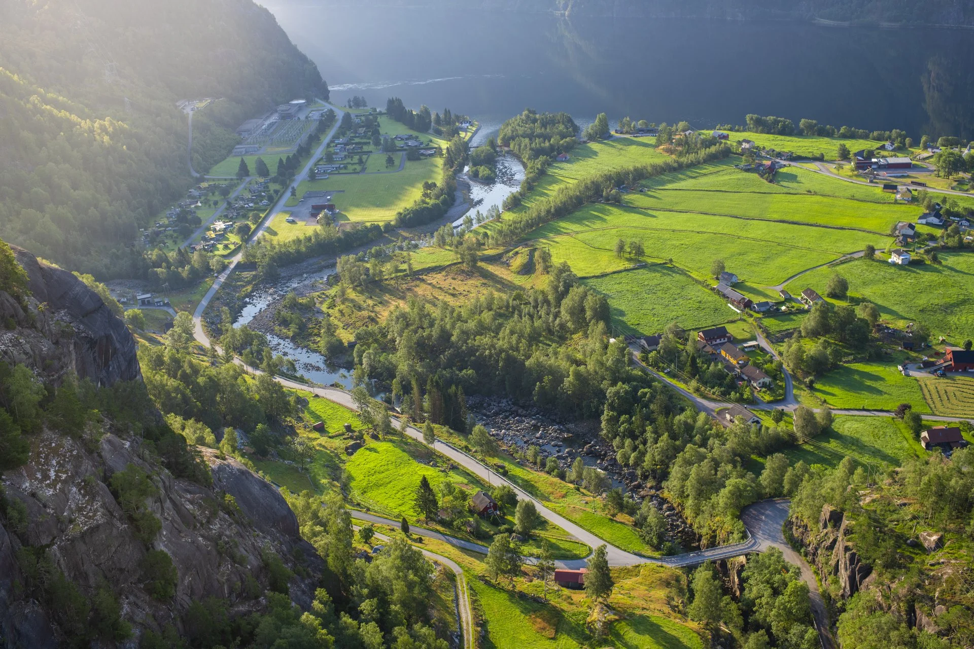 Luftfoto tatt over Nesflaten i Suldal med fjorden i bakgrunnen.