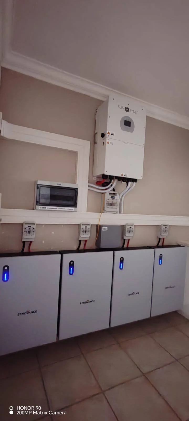 Solar inverter system with multiple batteries and electrical connections in a room.