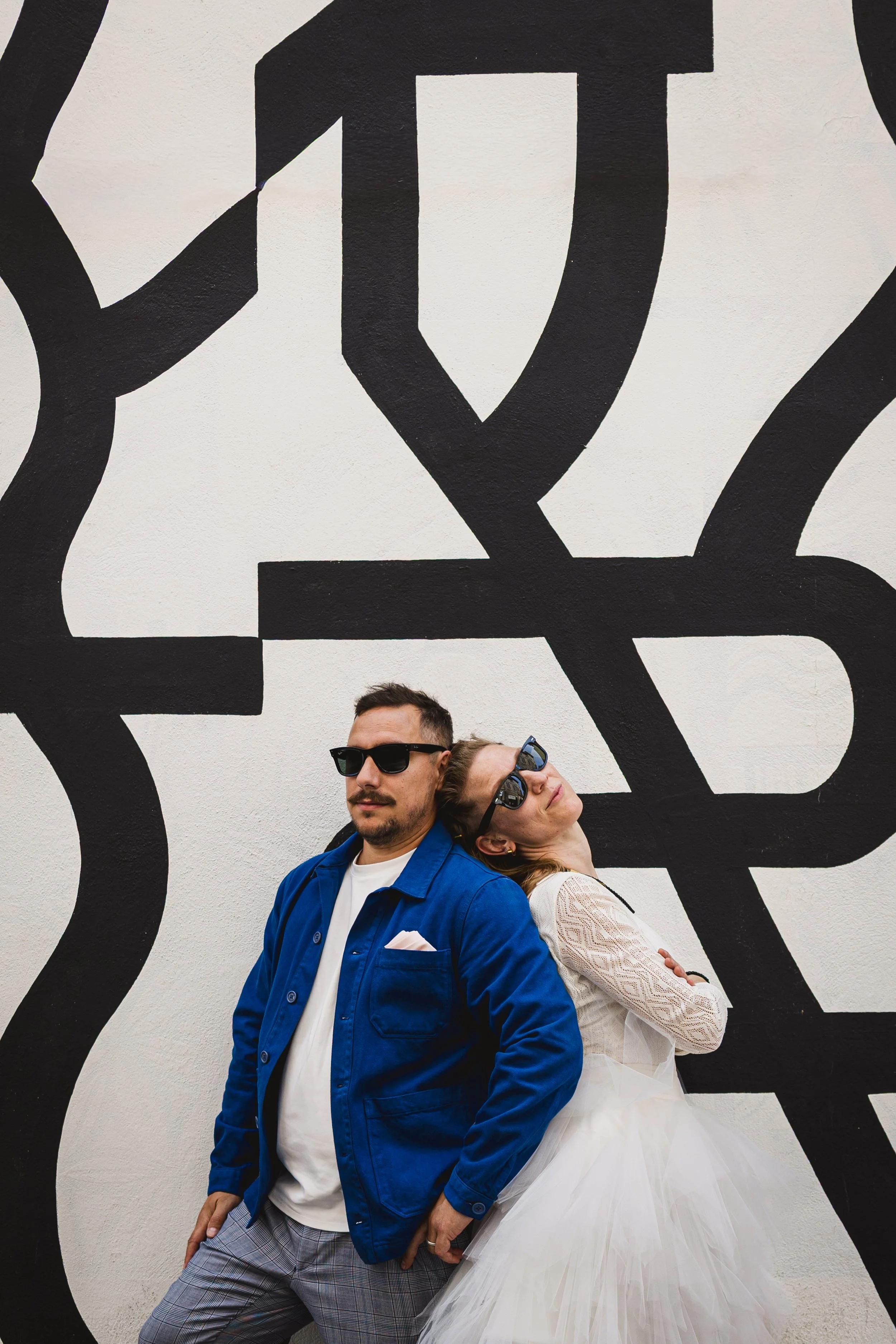 couple posant devant un mur de street art coloré et graphique en Provence en ville à Avignon