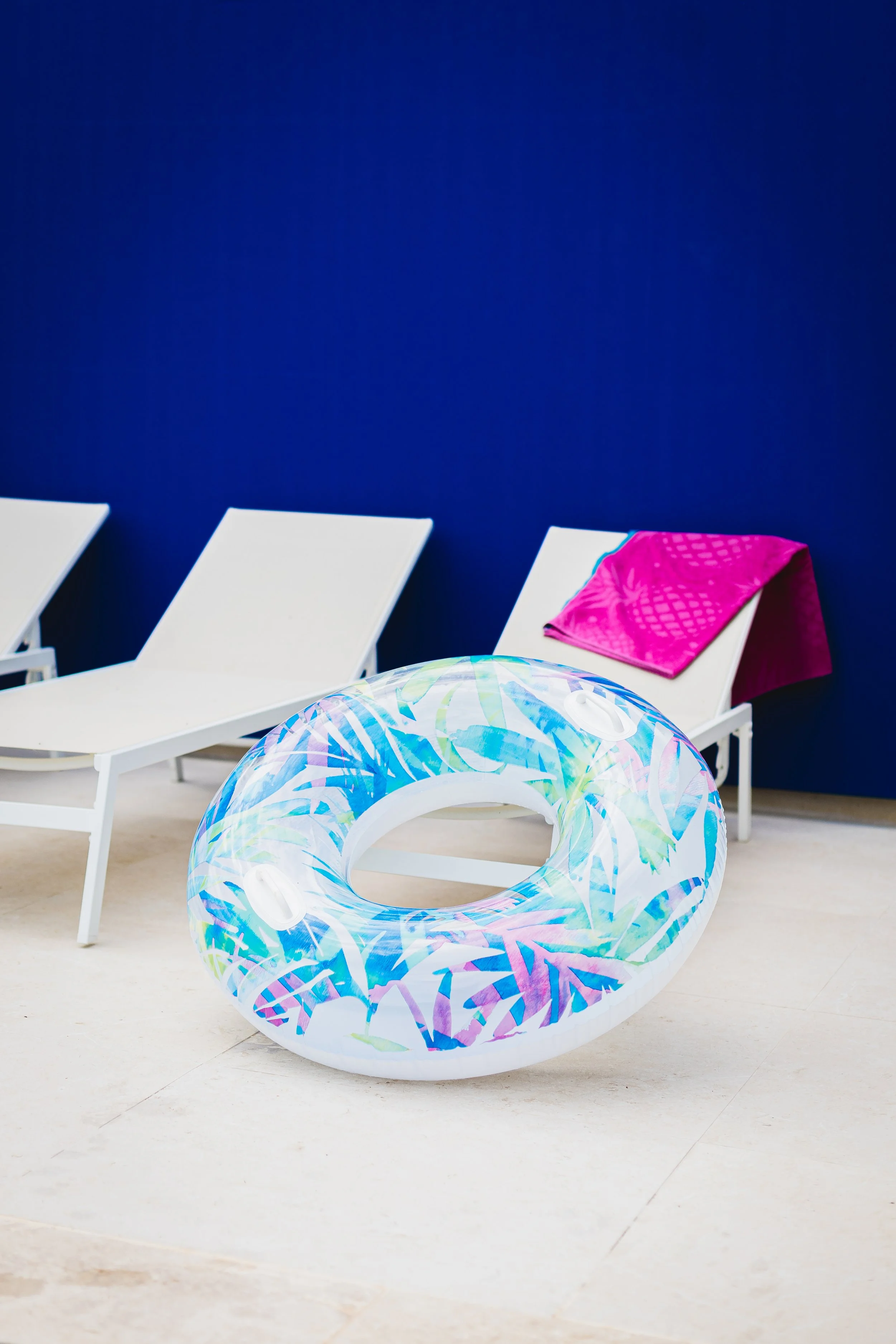 Photographie de reportage d’un extérieur immobilier avec chaises longues et une bouée dans un contexte de détente.