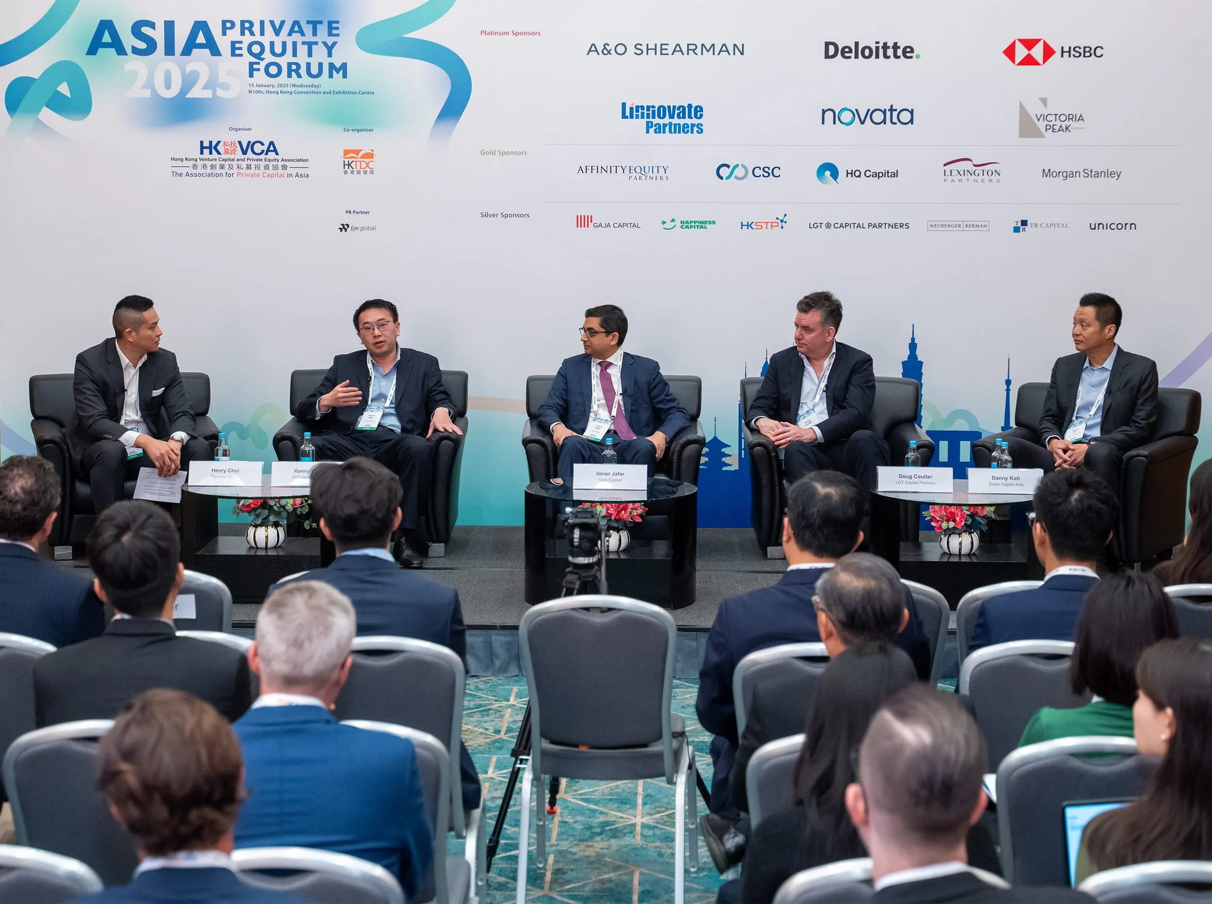 A panel discussion at the Asia Private Equity Forum 2023, with five men seated on stage, engaging in conversation. The backdrop displays the event's title, sponsors, and logos, while the audience watches attentively.