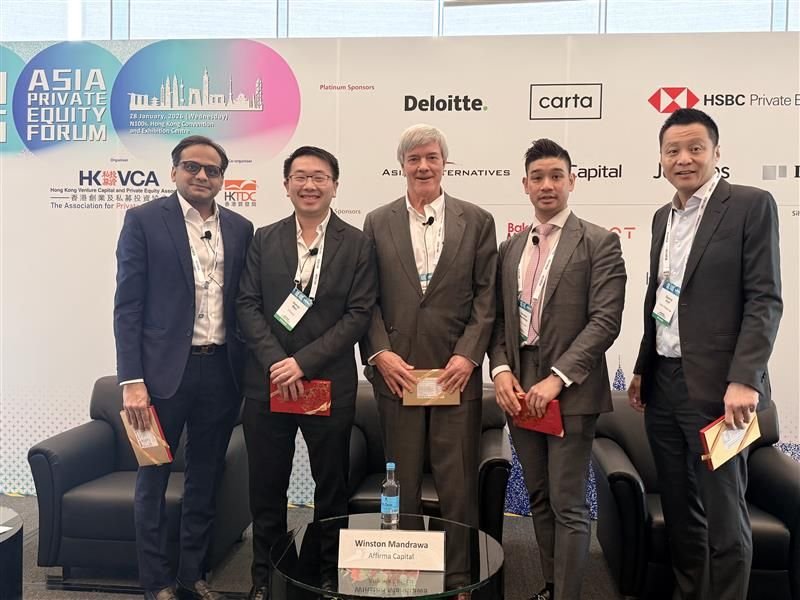 Group of five men in business attire standing in front of a conference backdrop at the Asia Private Equity Forum, holding certificates or awards, with a table displaying a water bottle and a nameplate reading 'Winston Mandawa, Afrima Capital'.