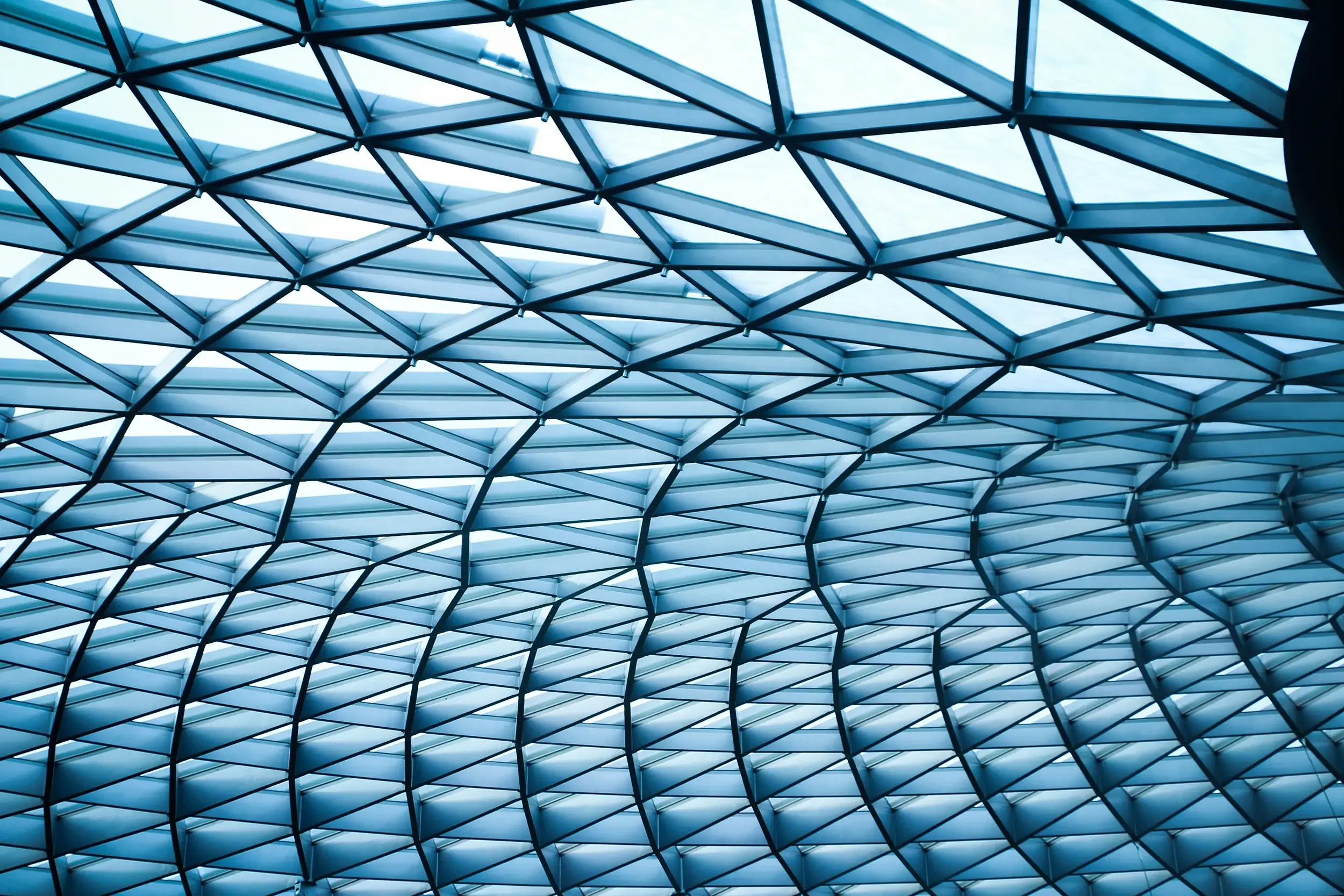 Interior view of a modern glass ceiling with a geometric lattice pattern.