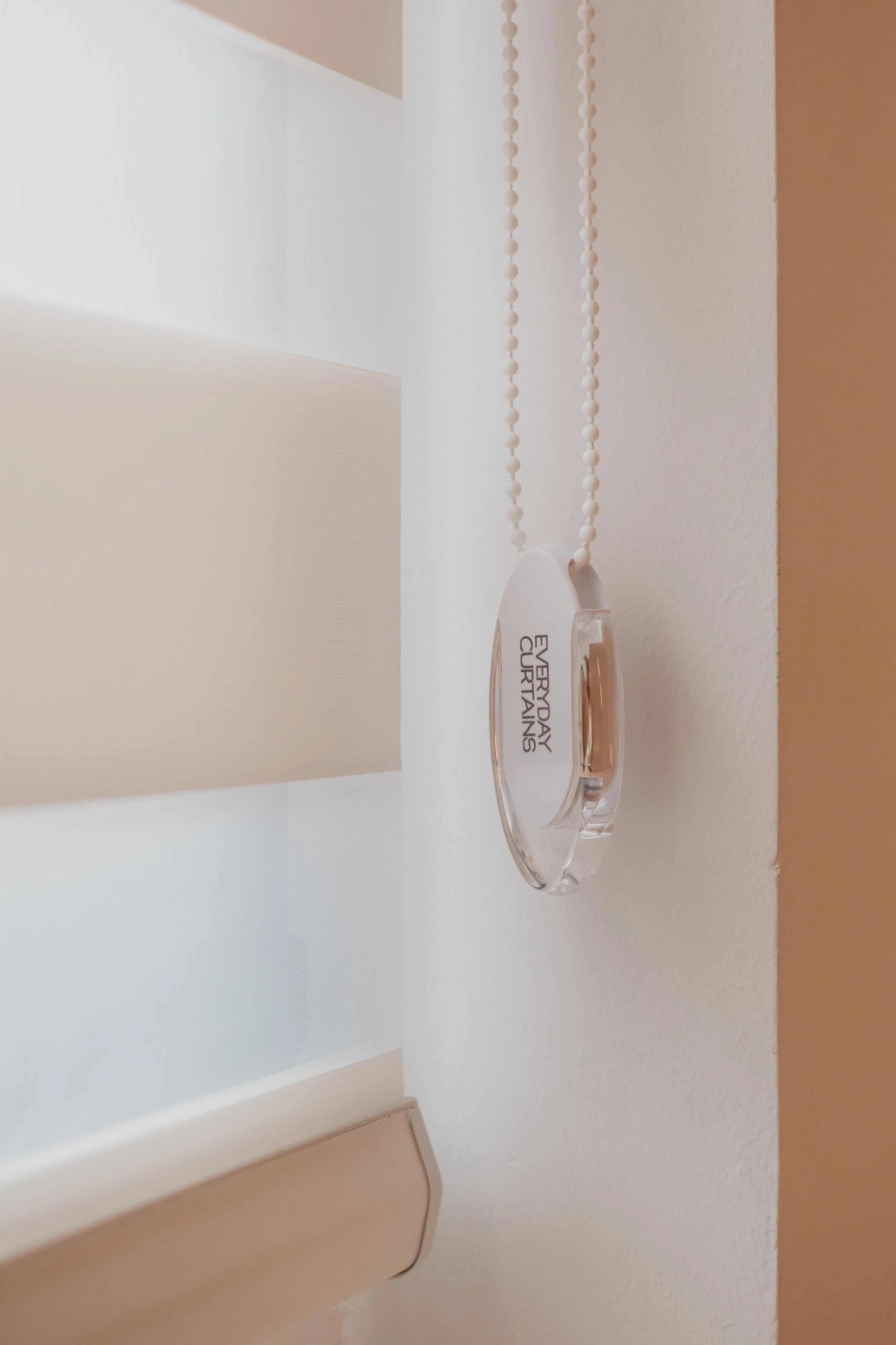 Korean blinds in a Singapore foyer, filtering soft natural light with a close-up of the Everyday Curtains chain control.