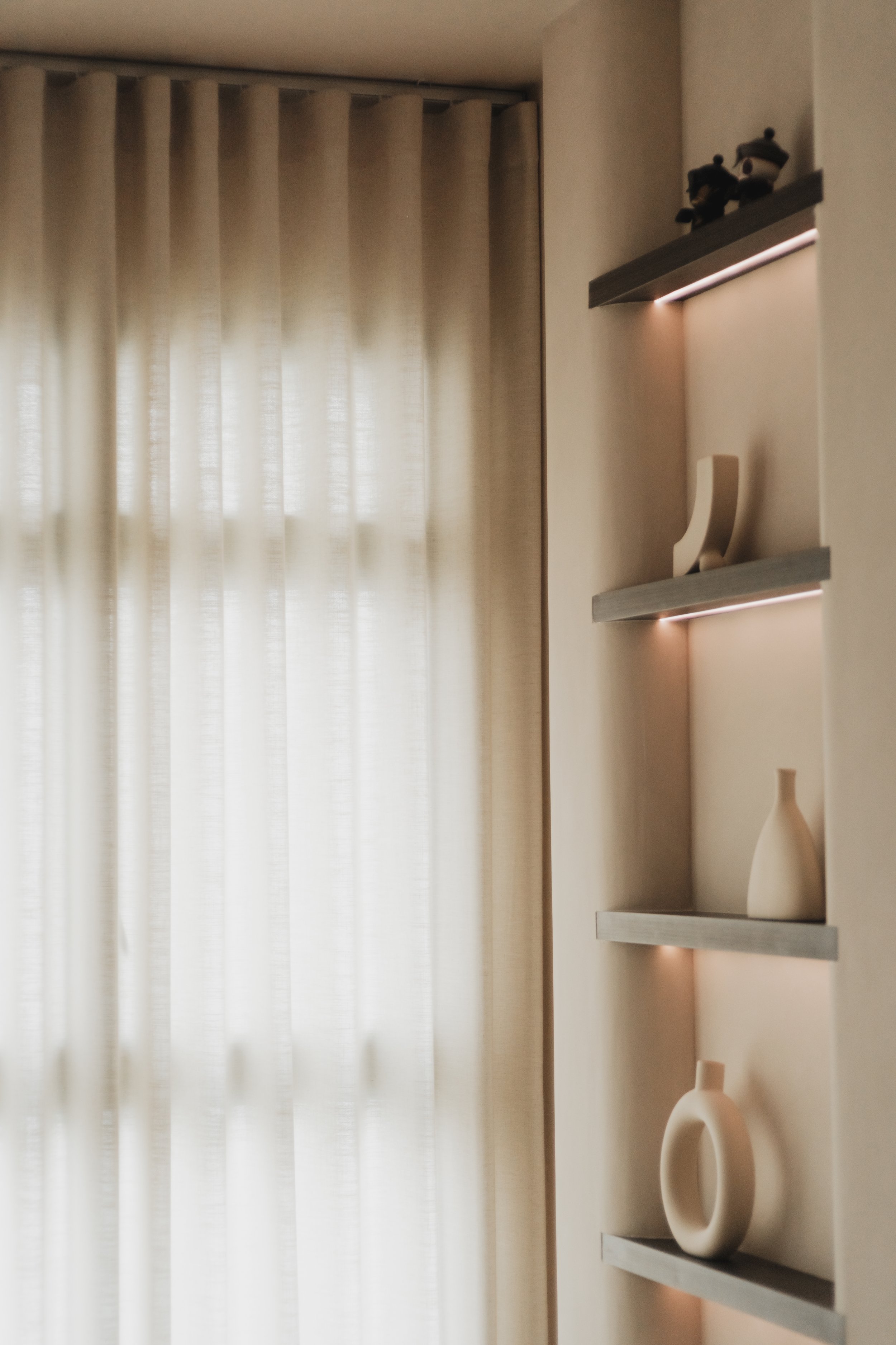 Full-height Lucent curtains in living room with natural light filtering through near display area.