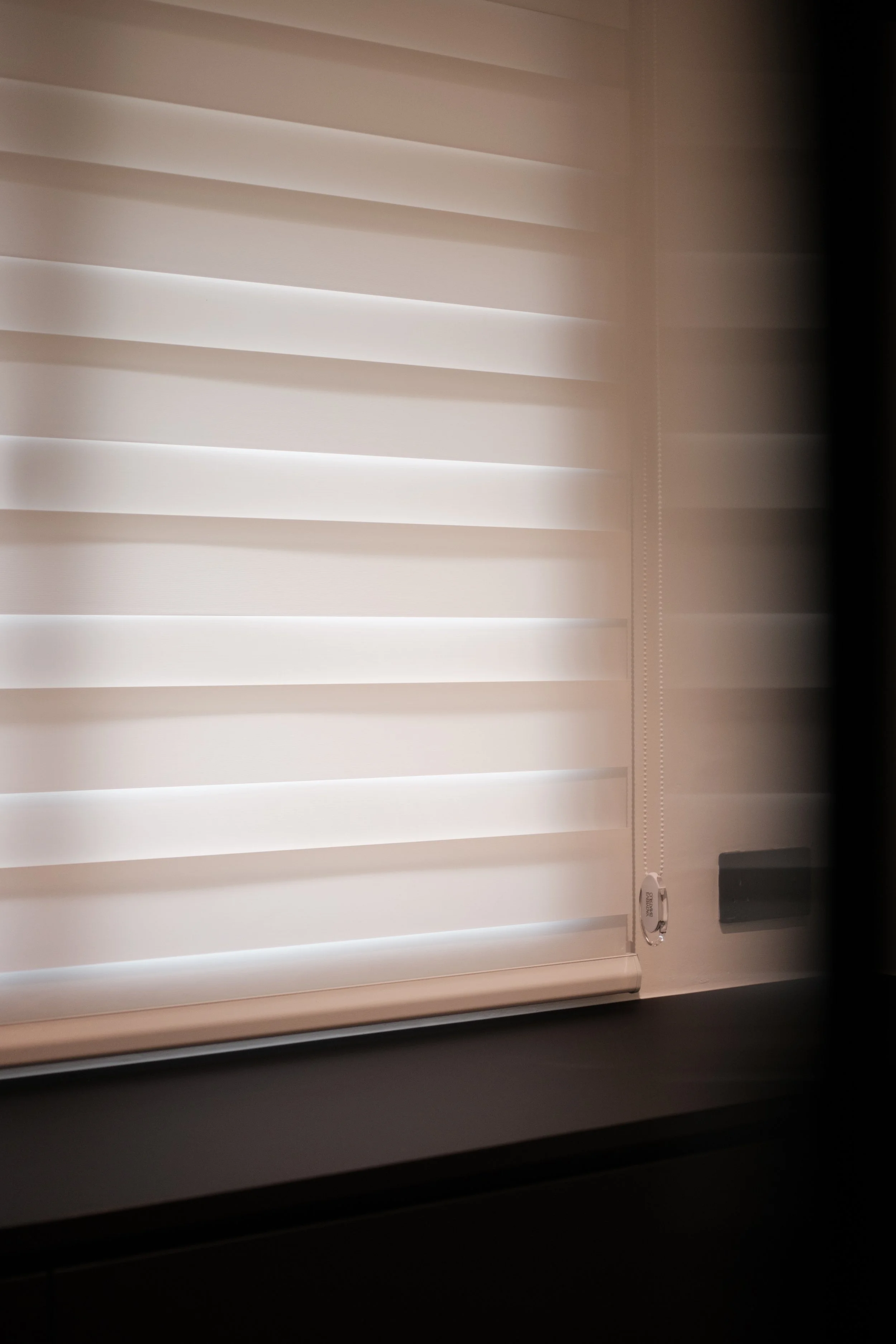 Korean blinds filtering soft natural light in a walk-in wardrobe with warm, moody interior tones.