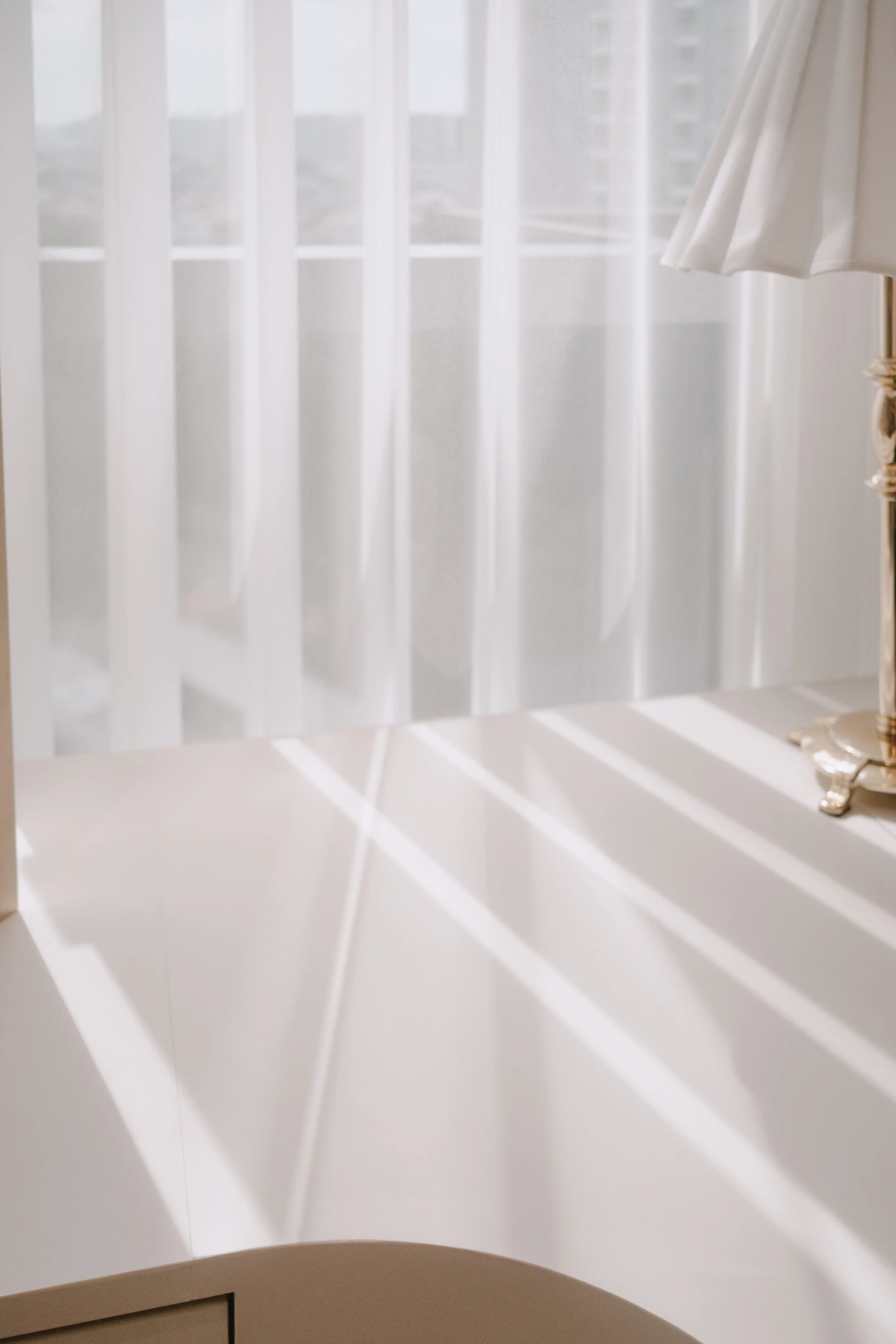 Close-up of Ripple Blinds casting soft lines of sunlight across a bright vanity surface.