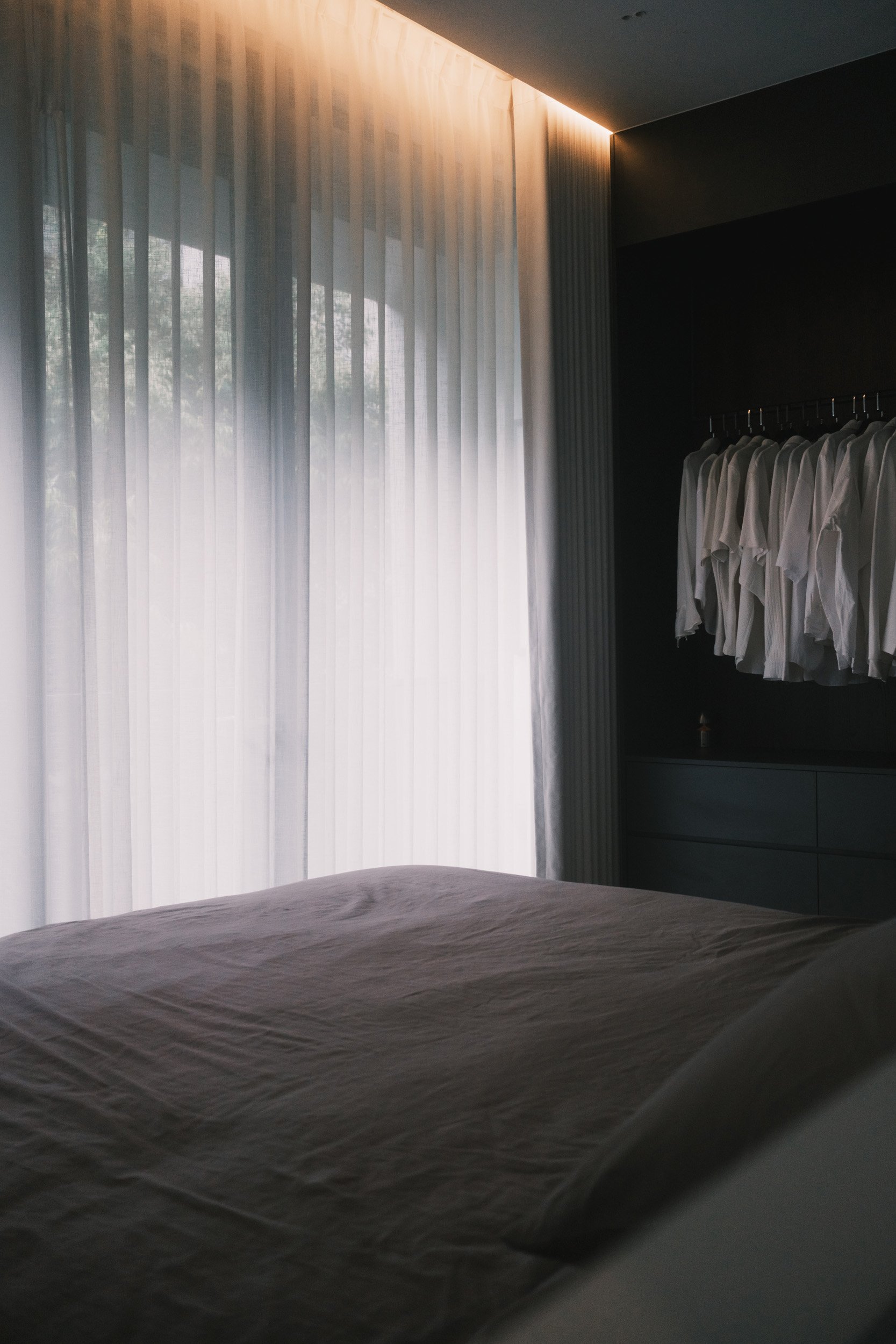 Natural light filtering through full-height Lucent and Somn curtains in bedroom onto wardrobe.