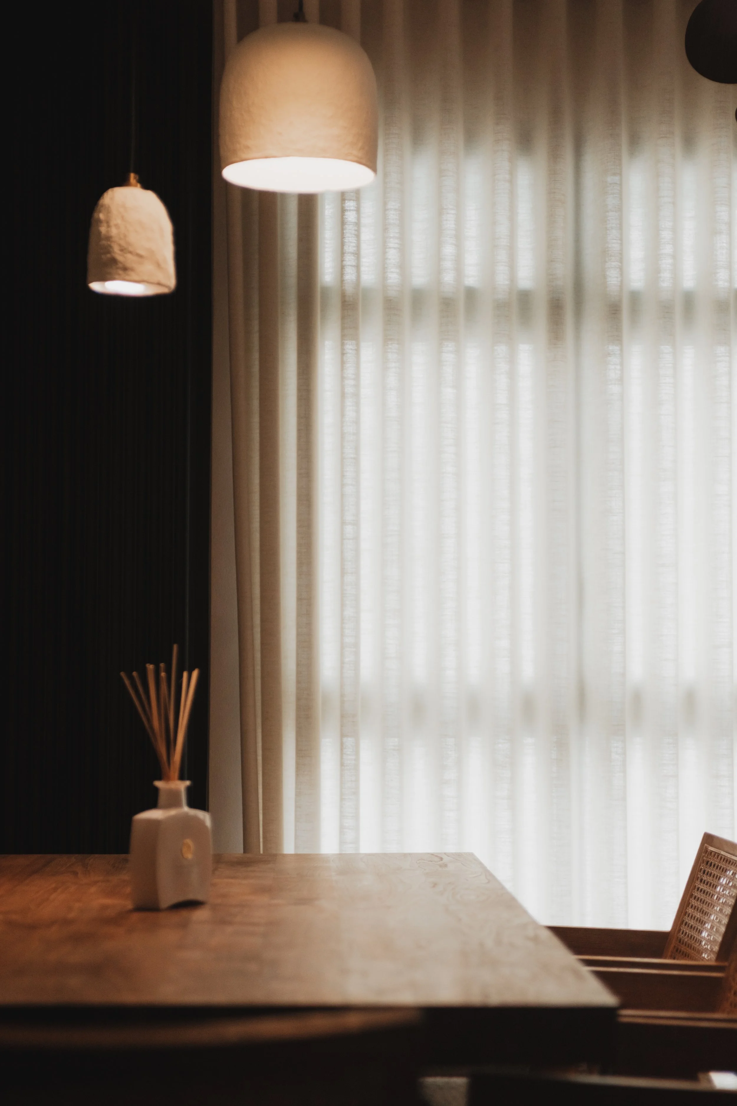 Full-height Lucent™ curtains in a Singapore BTO dining area, softly filtering natural light beside a warm wooden dining table.