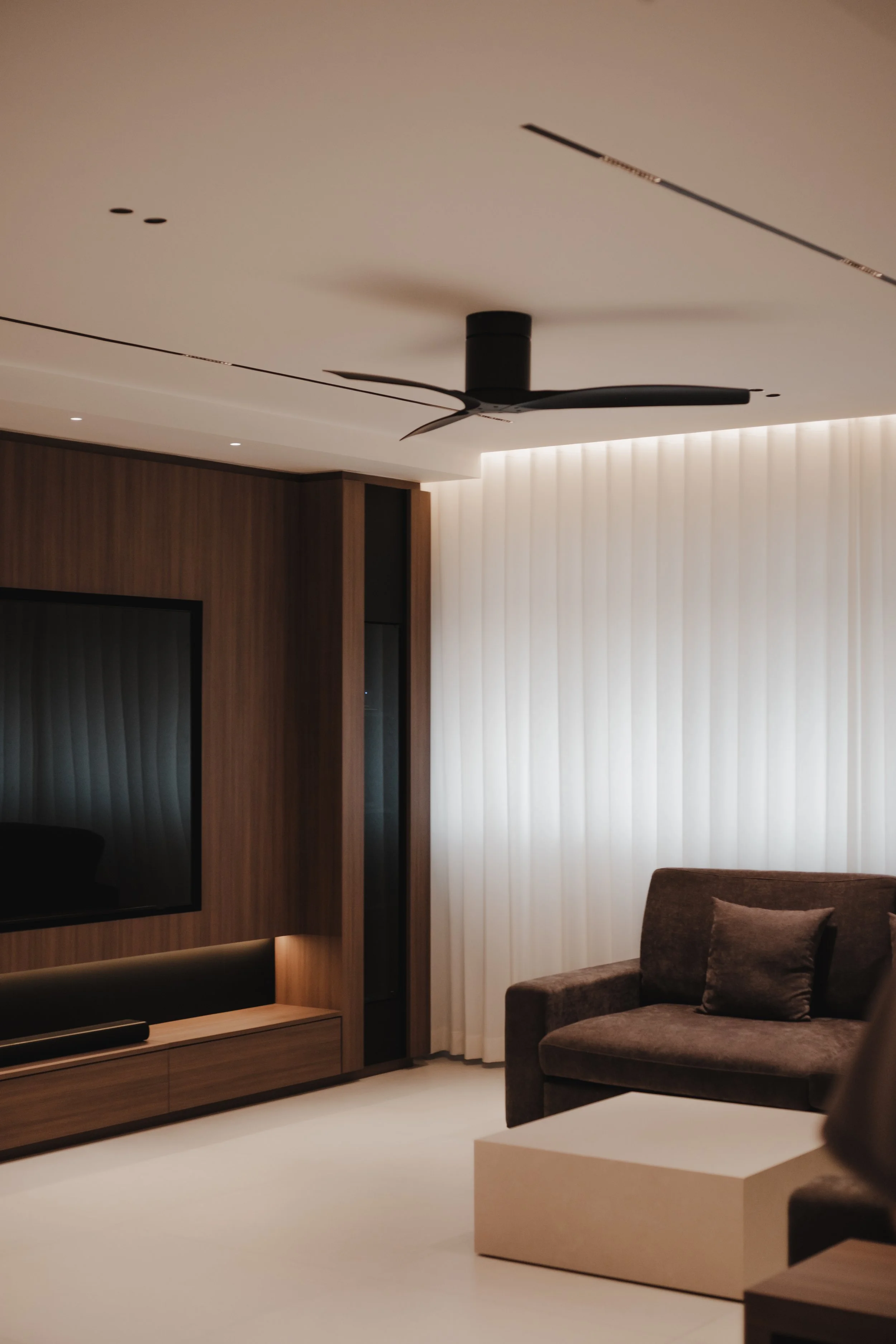 Lucent™ curtains filtering soft natural light in a modern Singapore living room with warm wood accents and minimalist furniture.
