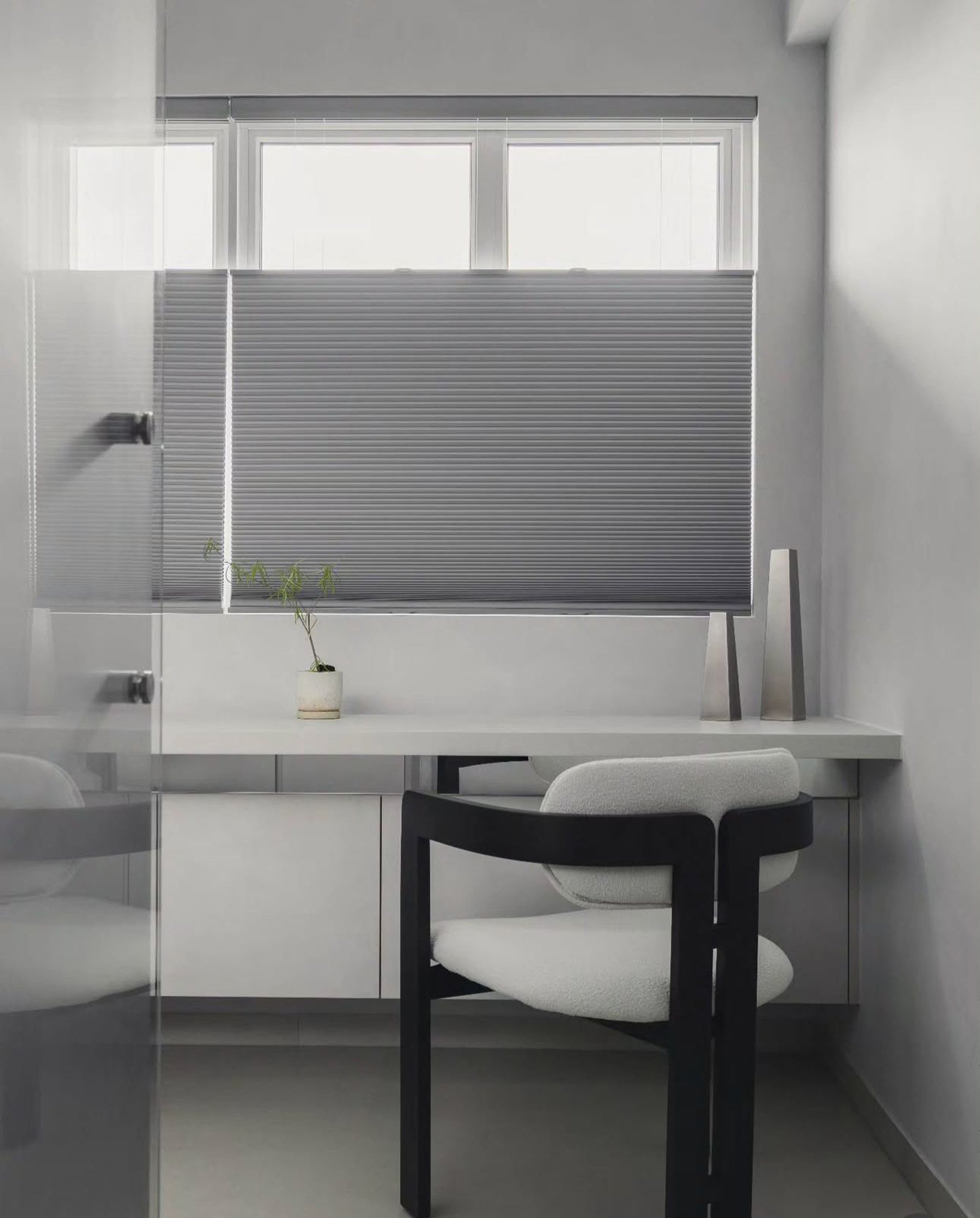 Honeycomb blinds in a Singapore HDB study room, partially covering the window to provide privacy while allowing natural light to enter.