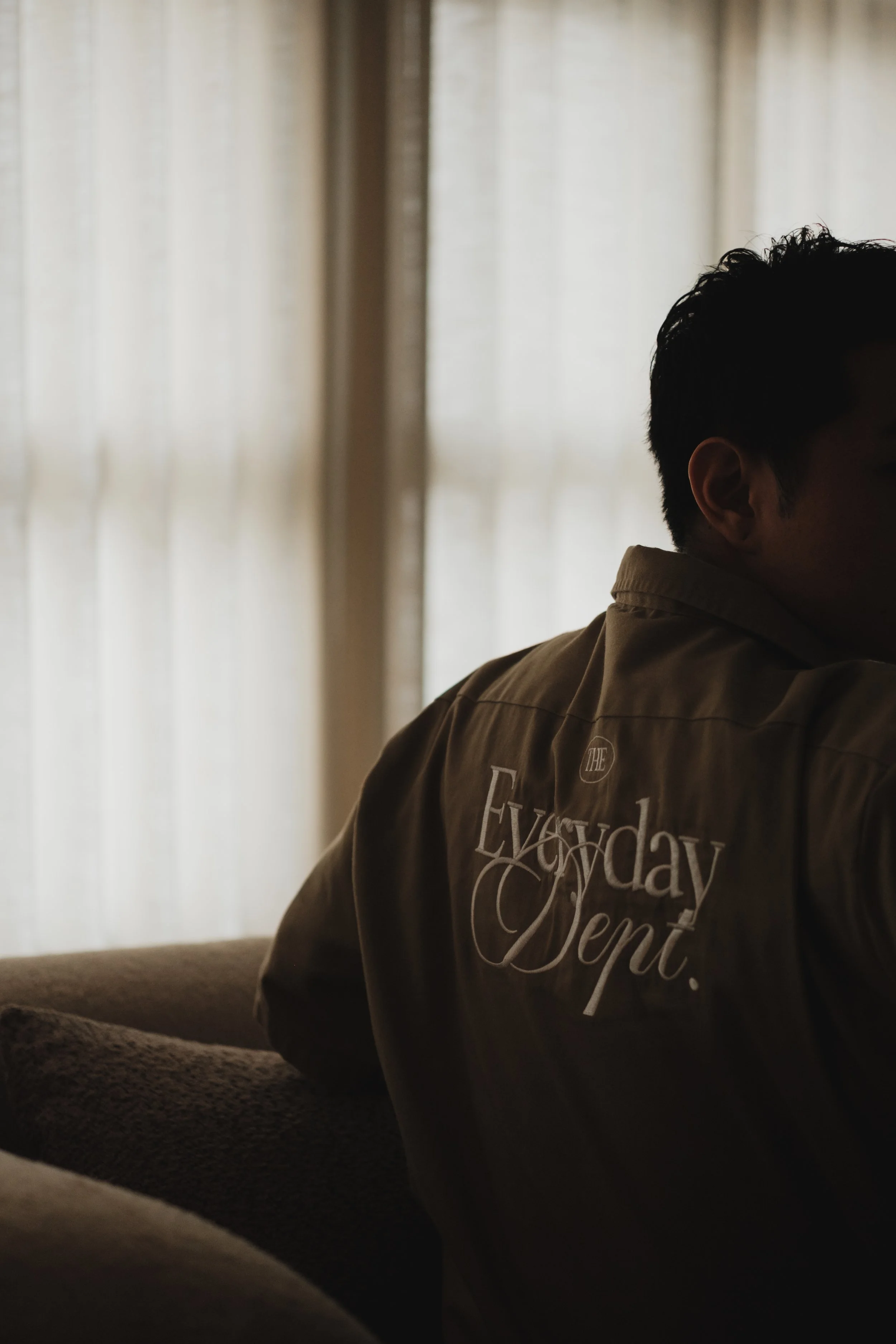 Curtains Singapore team member in an Everyday Curtains shirt seated indoors with soft curtains in the background, representing the brand behind the new facility.