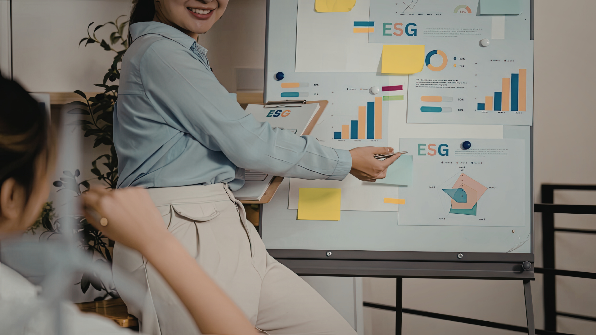 Person giving presentation with charts and graphs on a poster board about ESG.